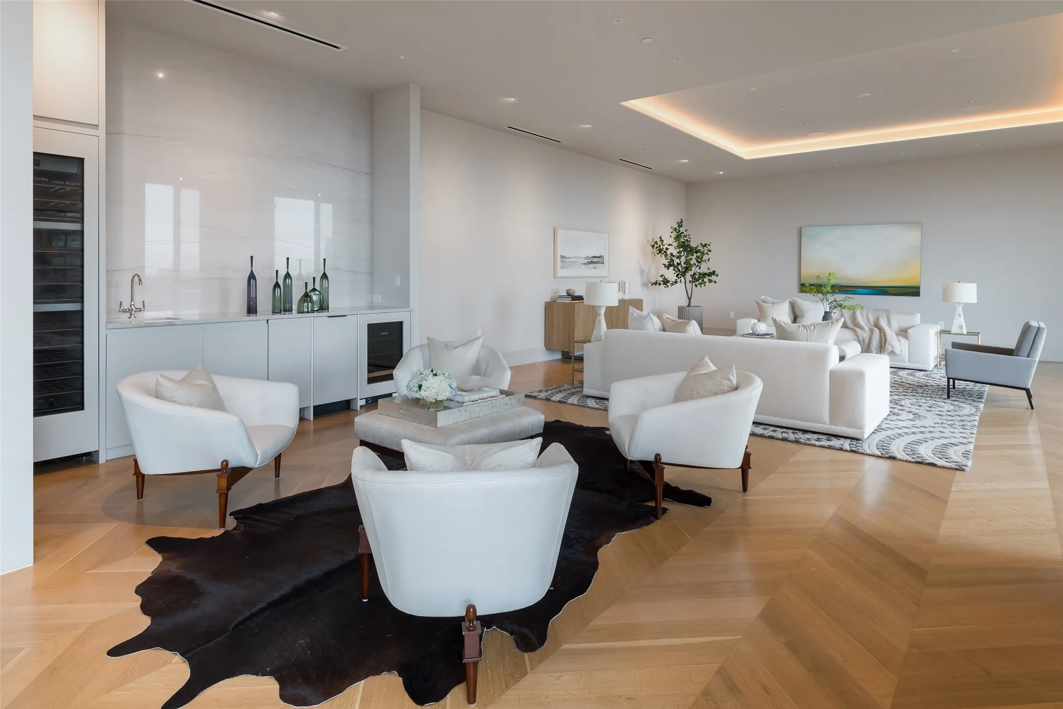 Living room with parquet flooring, wine cooler, a tray ceiling, and bar