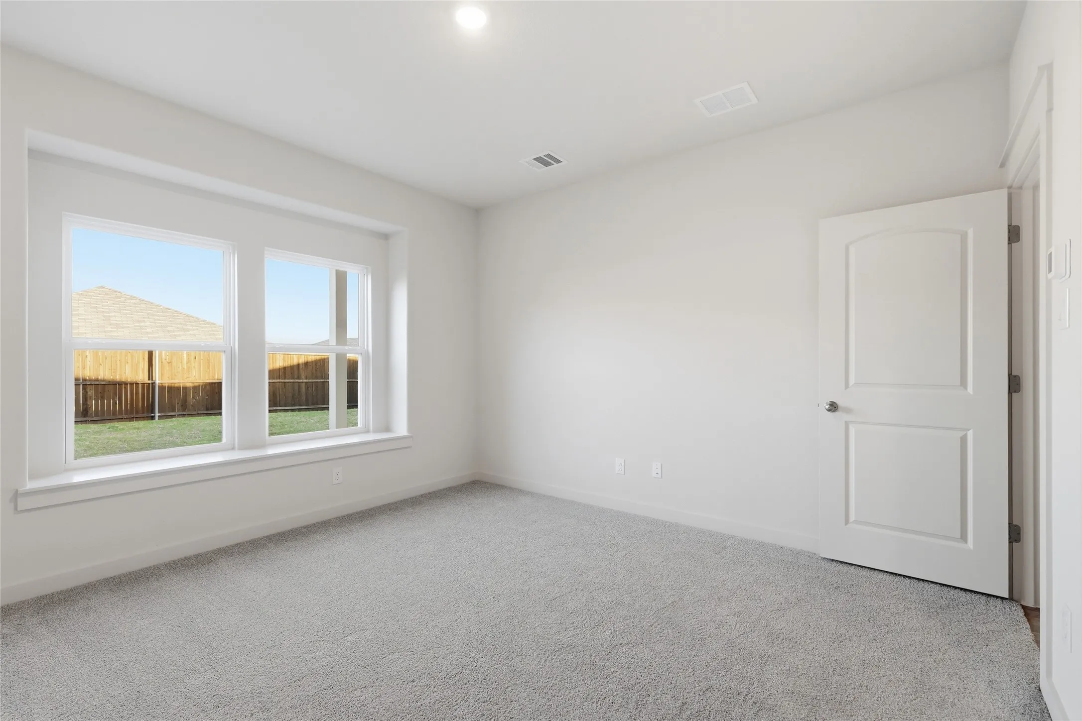 Bright room featuring light gray carpeting and white painted walls