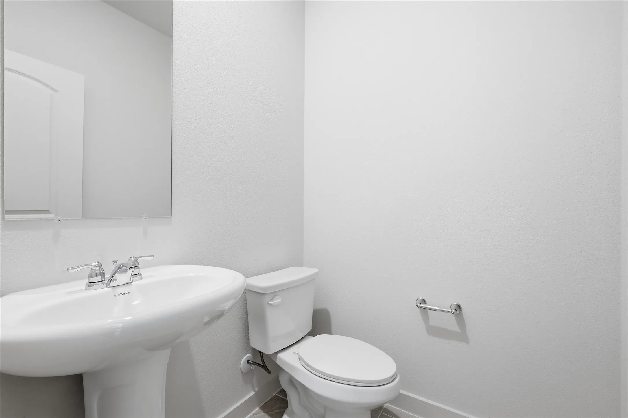 Pedestal sink with chrome fixtures and a rectangular mirror