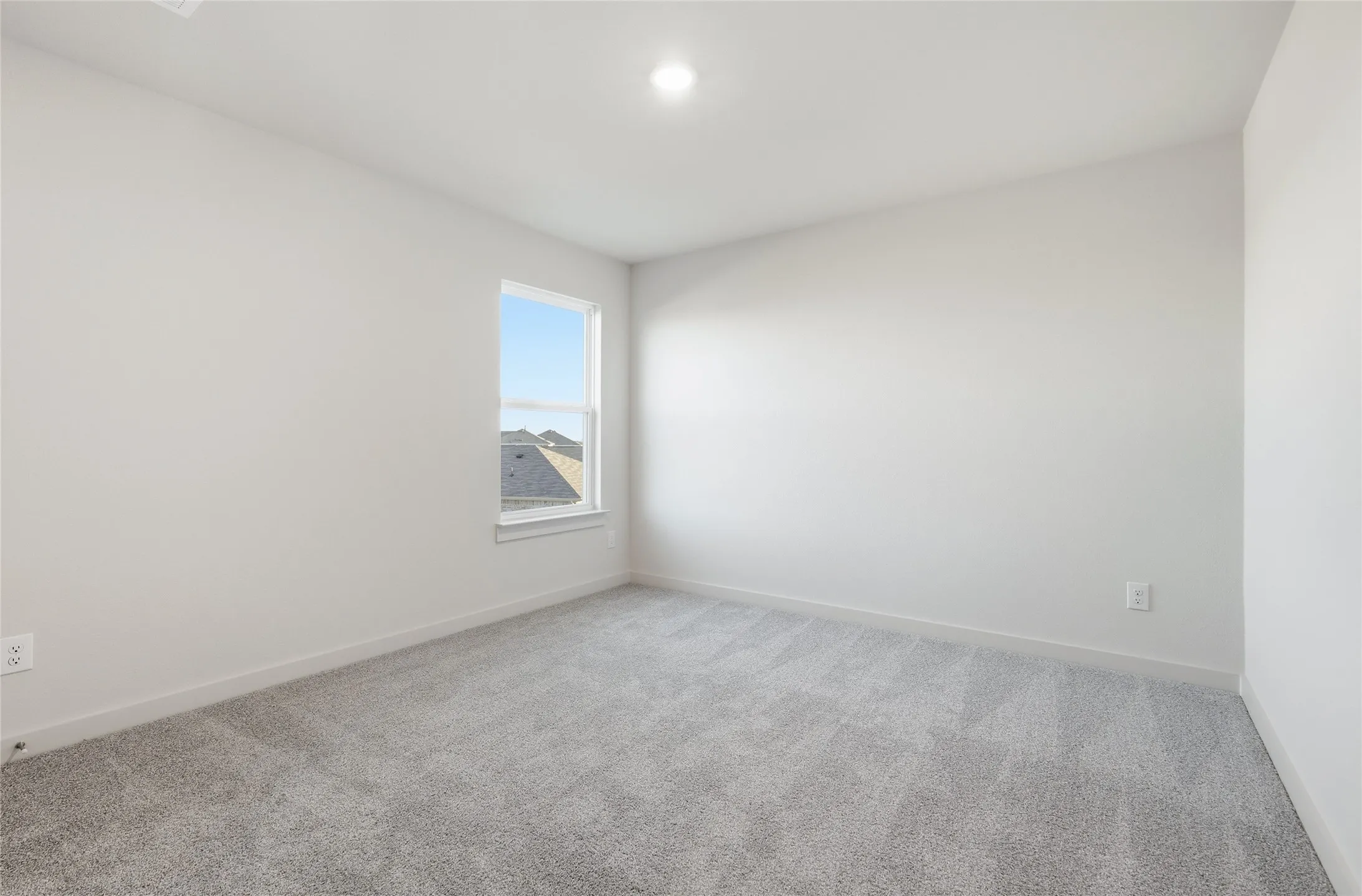 Neutral-toned room featuring a single window, recessed lighting, light gray carpeting, and white baseboards