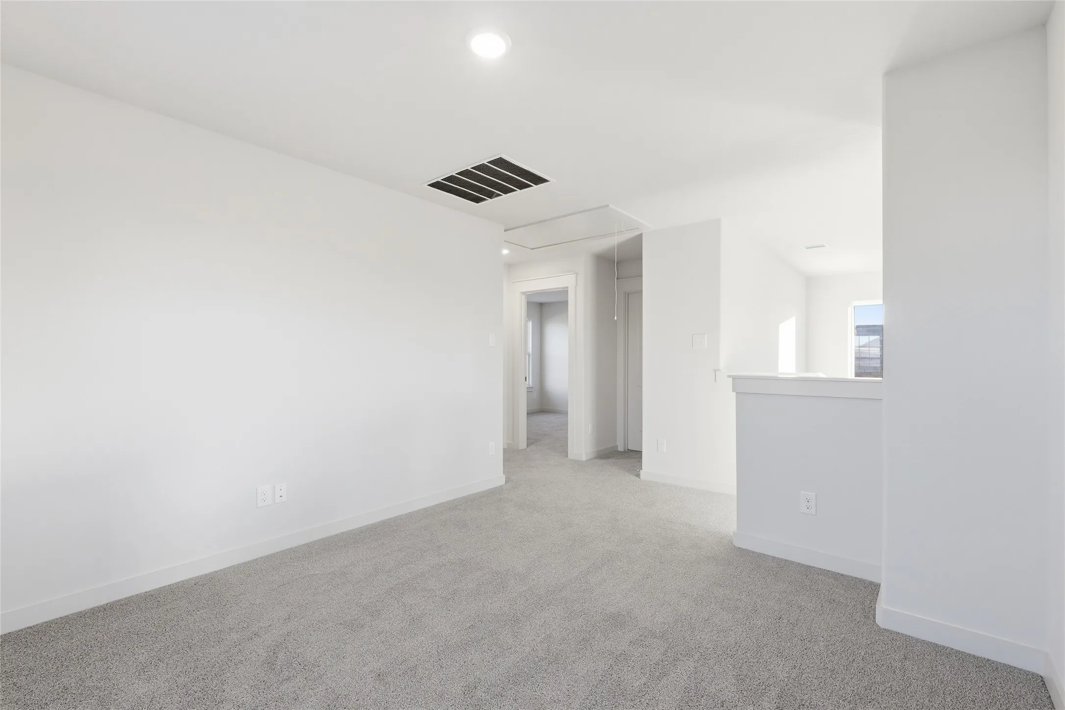 Carpeted room with white walls, recessed ceiling lighting, and a white baseboard trim