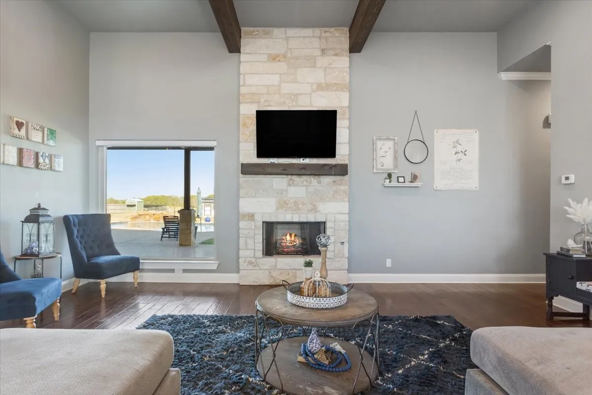 Living area with hardwood / wood-style floors, a fireplace, and beam ceiling