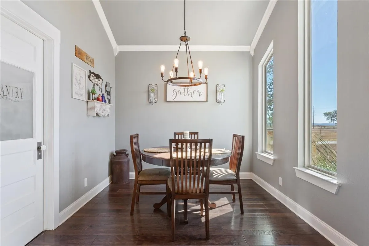 Dining room featuring crown molding, dark wood finished floors, and suspended lighting