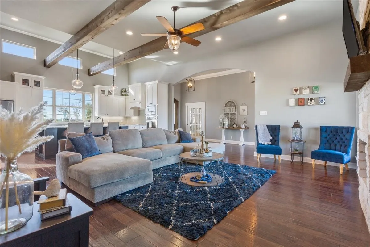 Living room with ceiling fan, dark wood finished floors, arched walkways, recessed lighting, and ornamental molding