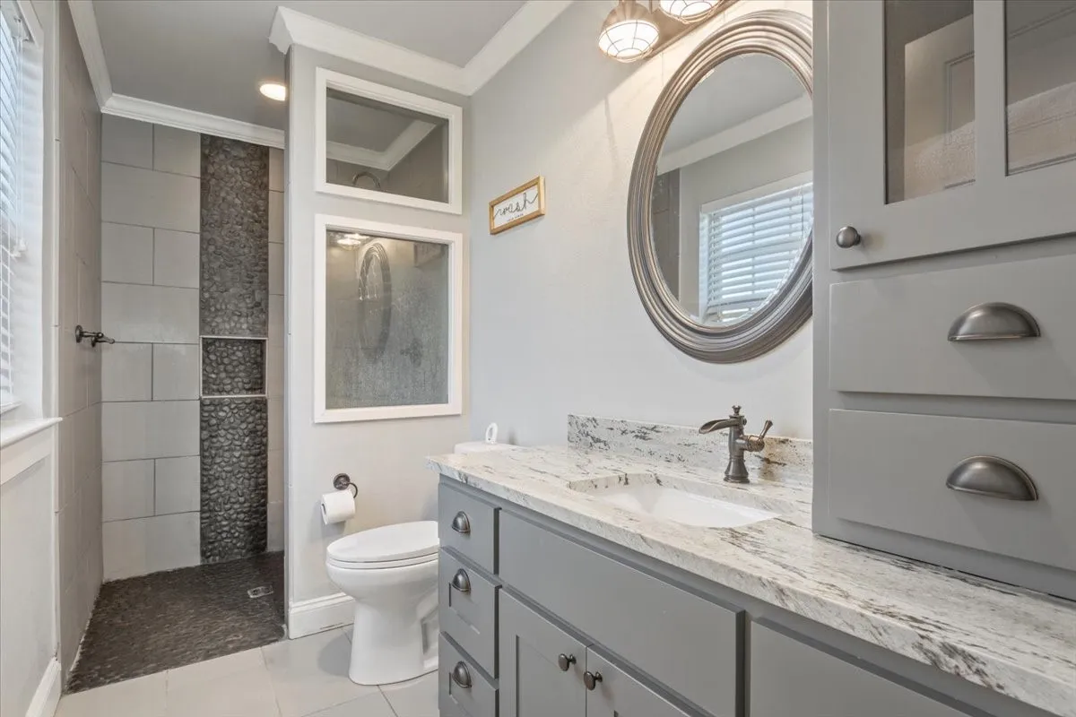 Bathroom with vanity, crown molding, a walk in shower, and light tile patterned floors