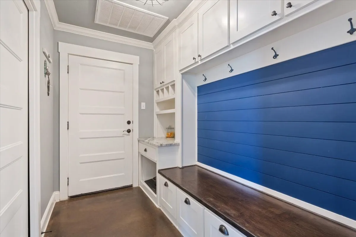 Mudroom with finished concrete flooring and crown molding