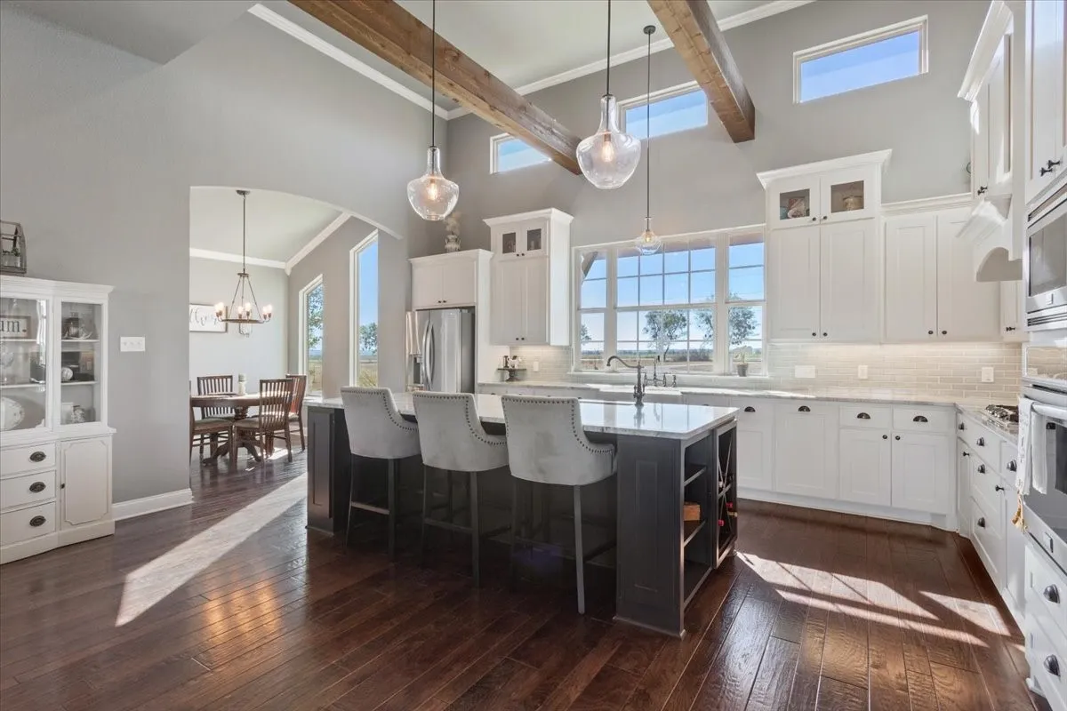 Kitchen featuring glass insert cabinets, crown molding, open shelves, a breakfast bar, and decorative backsplash