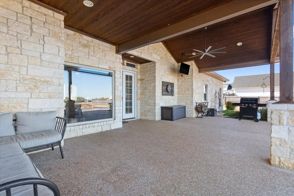 View of patio with ceiling fan and grilling area