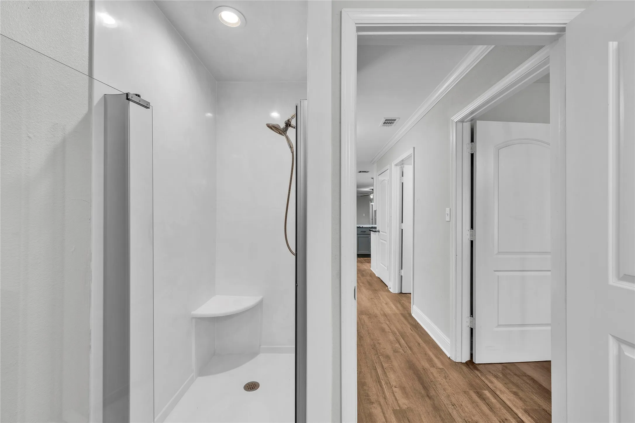 2nd primary Master or mother in law Bathroom with a shower stall, light wood-type flooring, ornamental molding, and recessed lighting