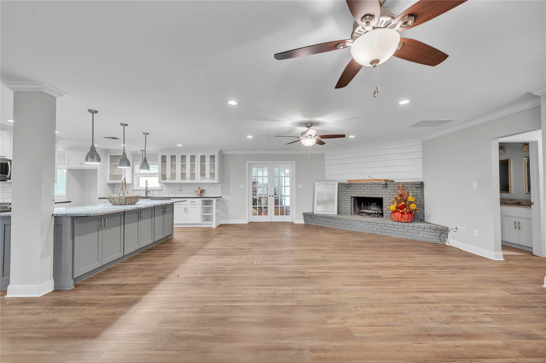 Unfurnished living room with a fireplace, light wood-type flooring, crown molding, recessed lighting, and ceiling fan