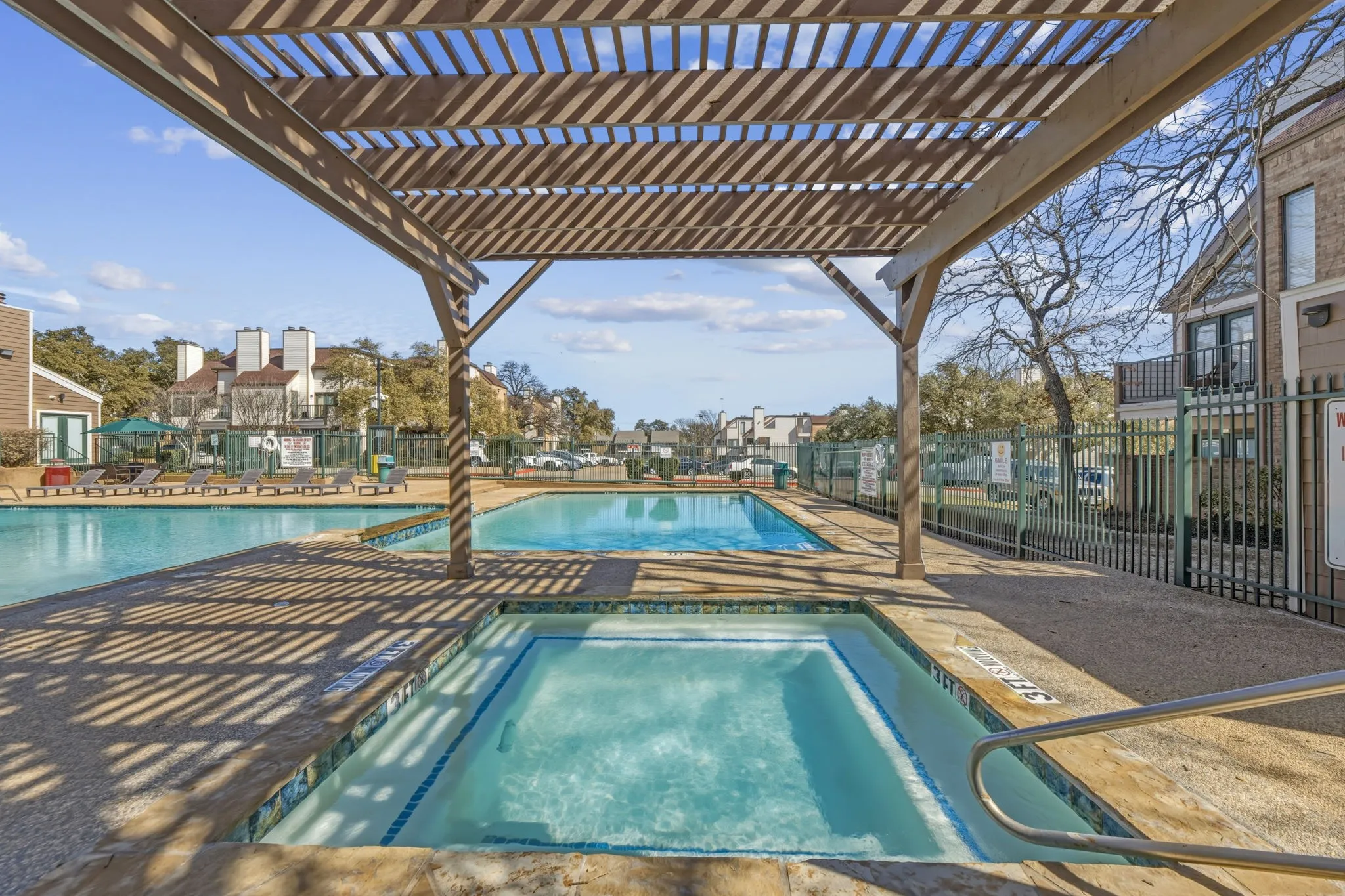 Community pool with a community hot tub, a patio area, and a pergola