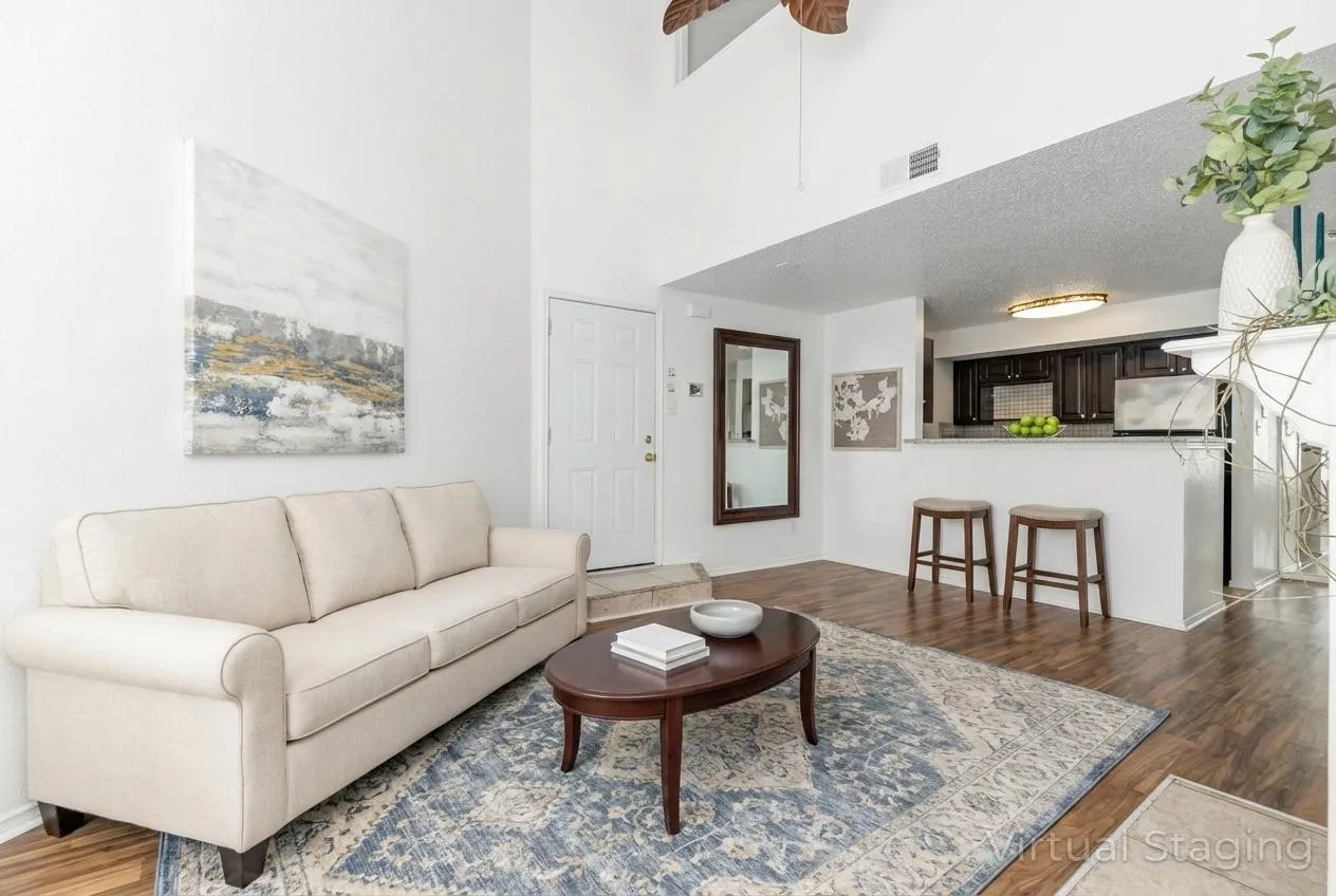 Living area with dark wood-style floors, a ceiling fan, and a high ceiling