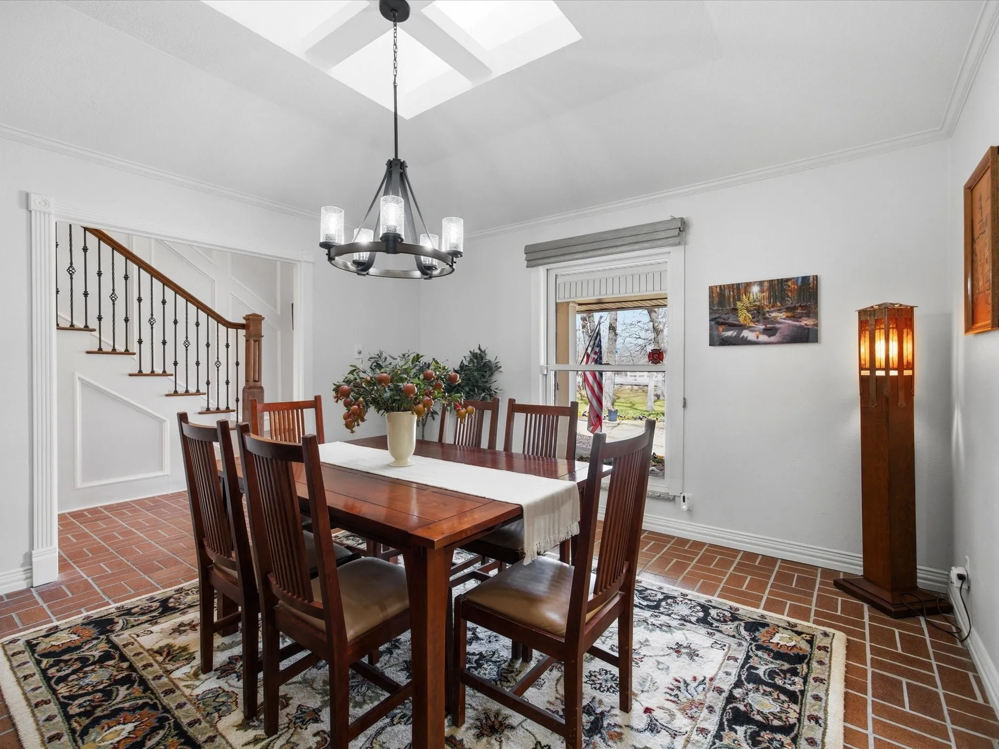 Dining area featuring brick flooring, ornamental molding, and suspended lighting