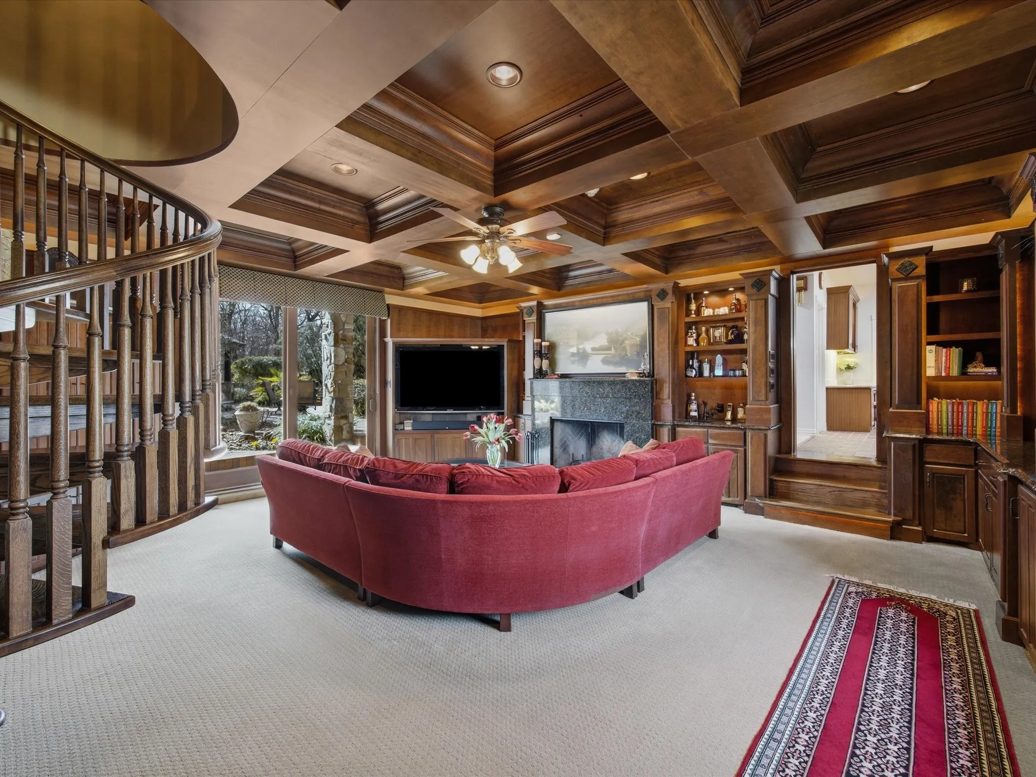 Library with light colored carpet, coffered ceiling, a fireplace, crown molding, and ceiling fan