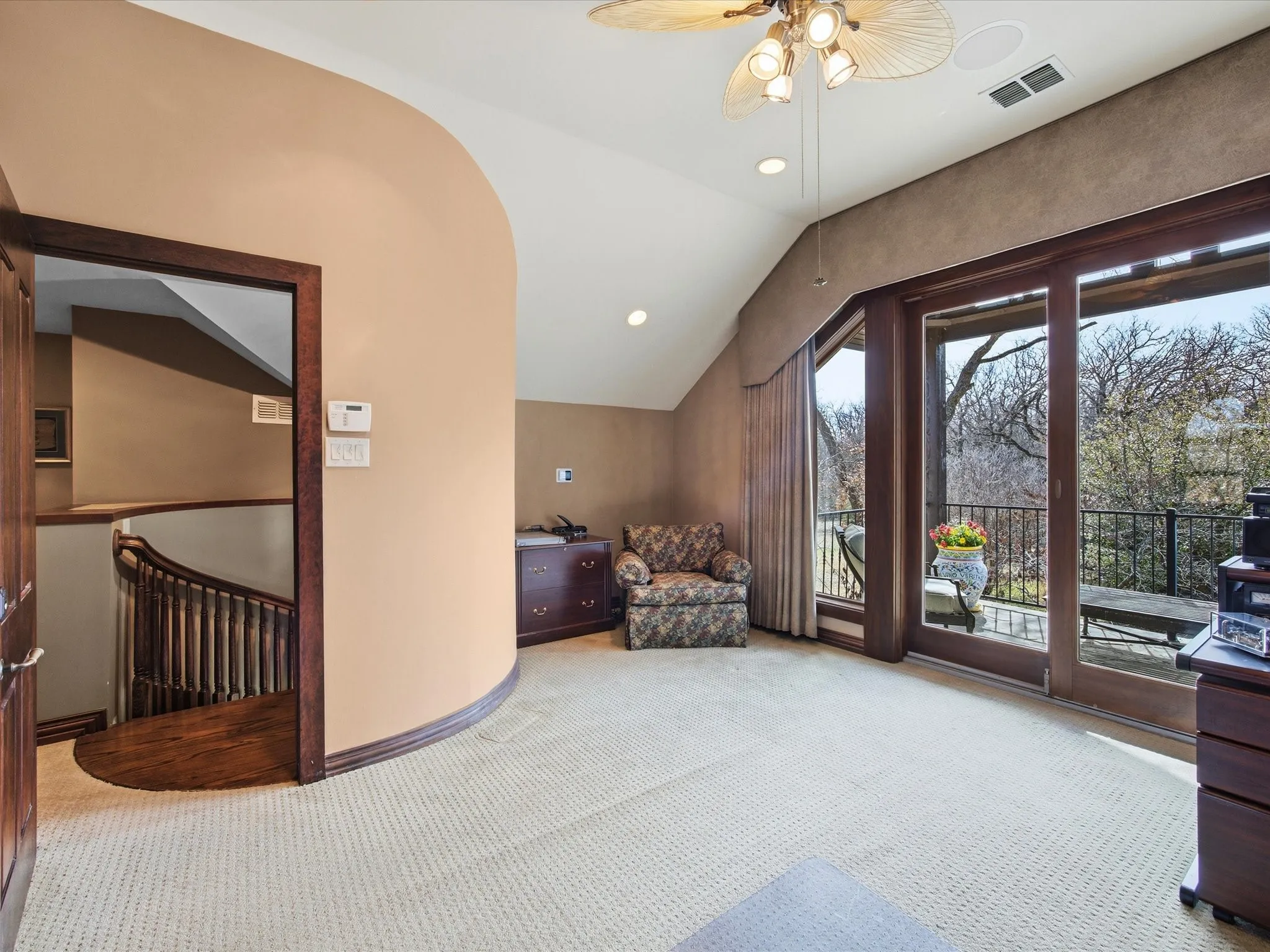 Bedroom featuring recessed lighting, light carpet, a ceiling fan, vaulted ceiling, an ensuite bath and an upstairs landing