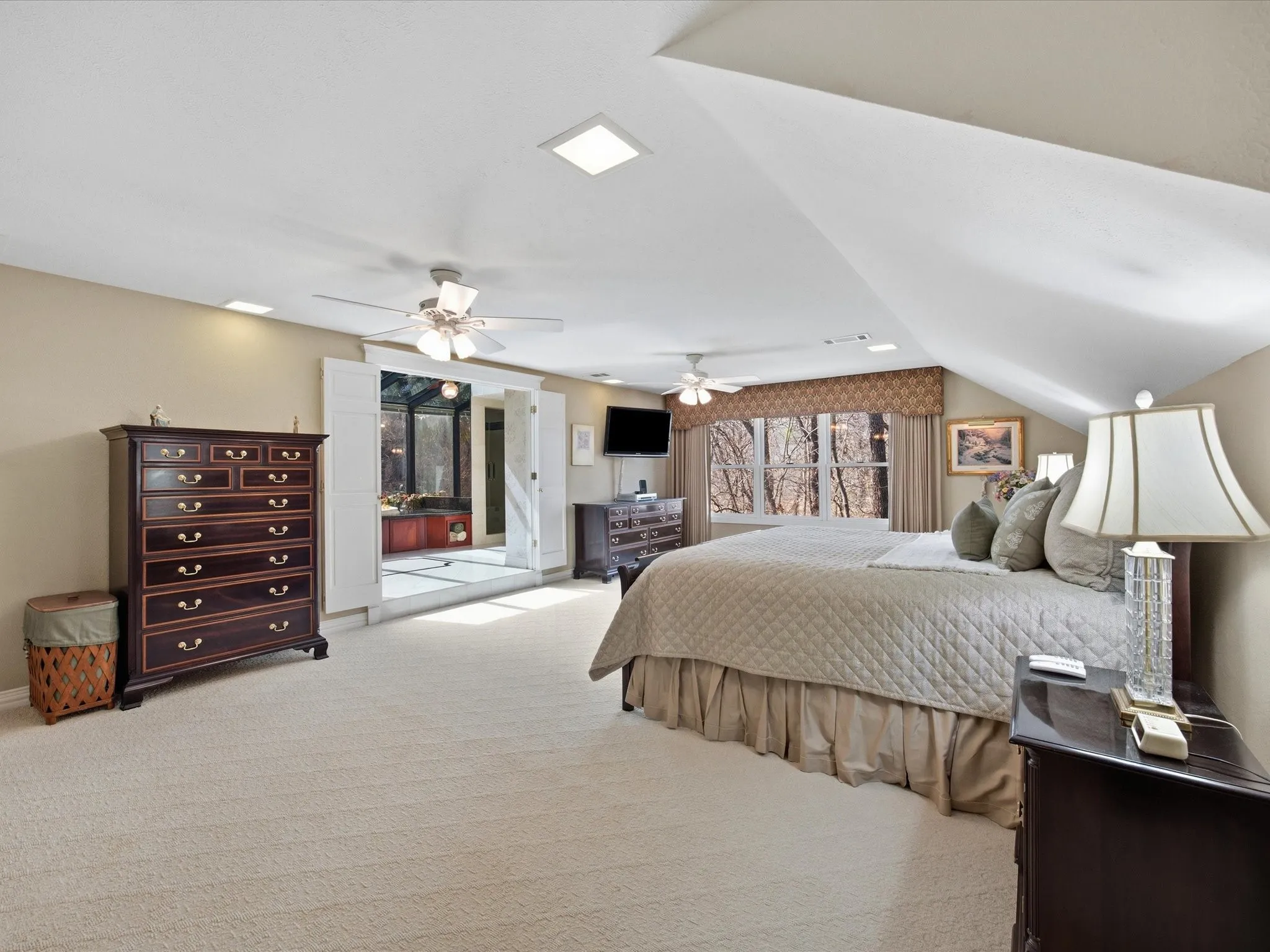 Upstairs Primary Bedroom with light carpet, a ceiling fan, and ensuite bathroom