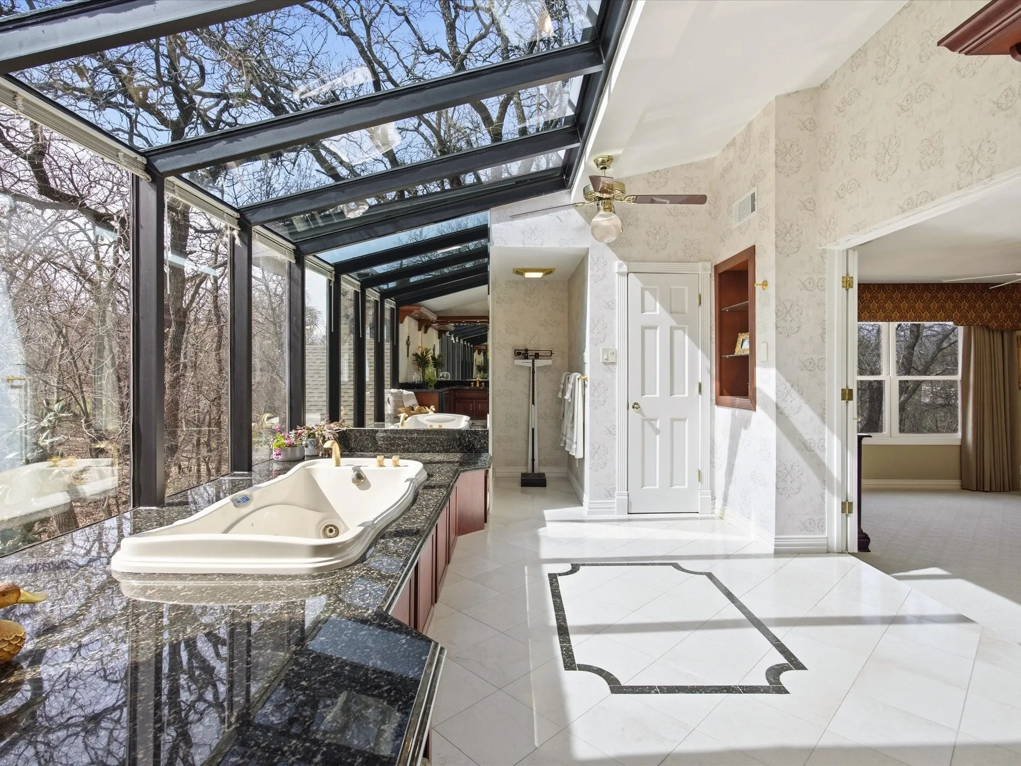 Upstairs Primary Bathroom with wallpapered walls, a jetted tub, light tile patterned flooring, and vanity