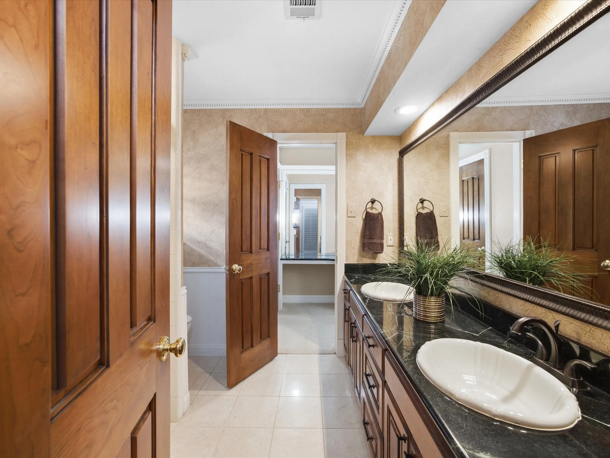 Full bathroom with crown molding, double vanity, and light tile patterned floors