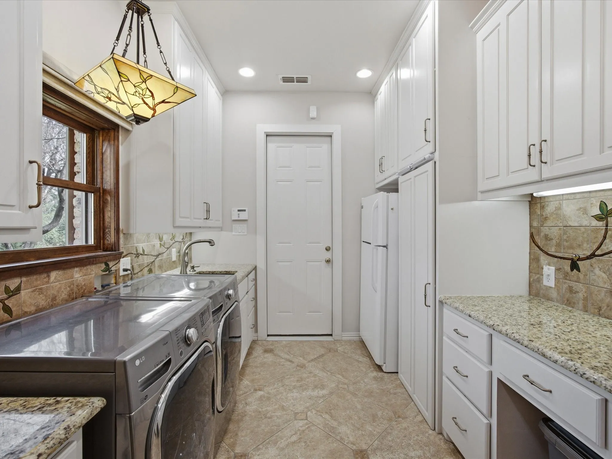 Laundry area featuring washer and dryer, cabinet space, and recessed lighting