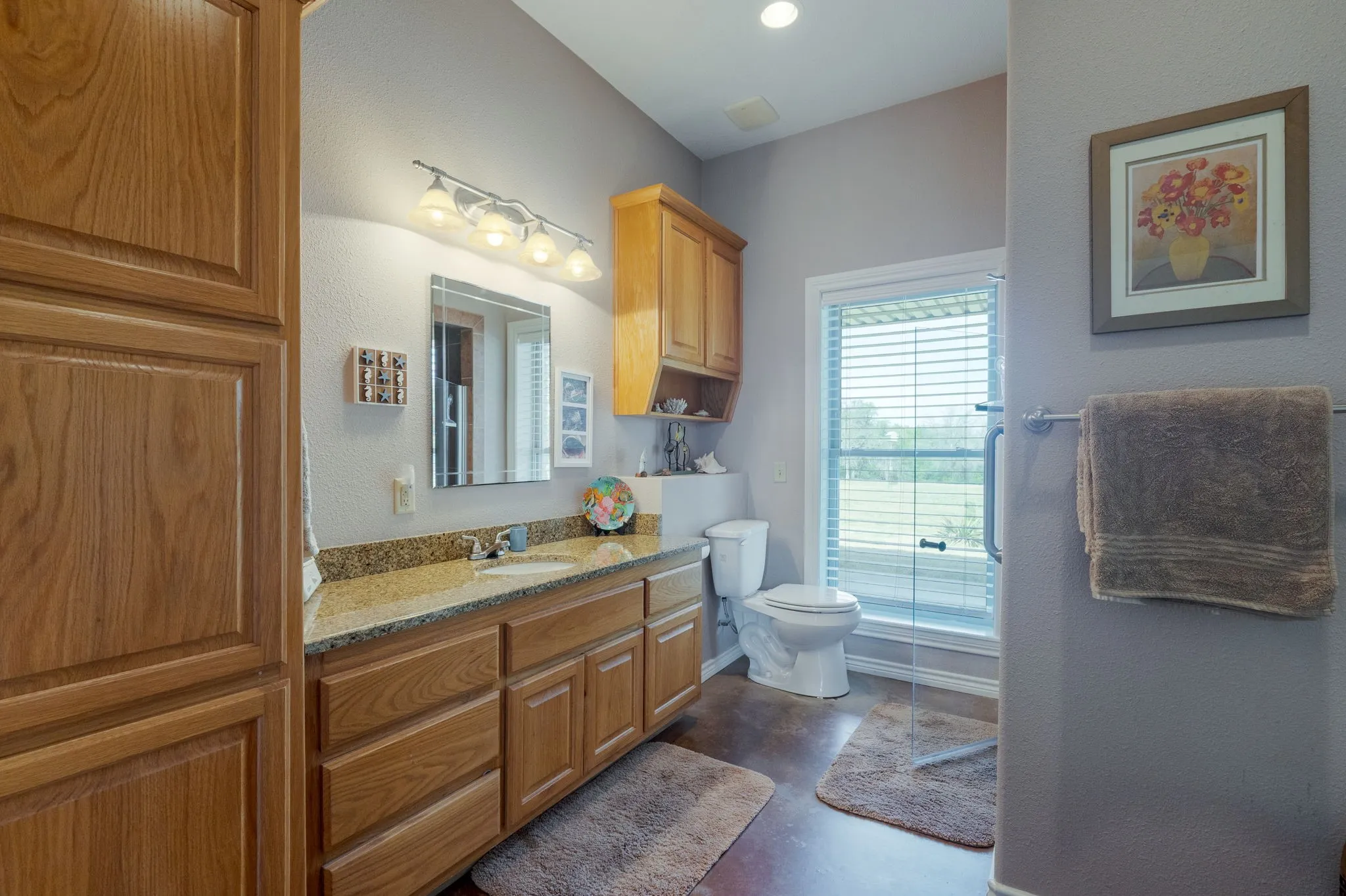 Full bathroom featuring vanity, concrete flooring, and a textured wall