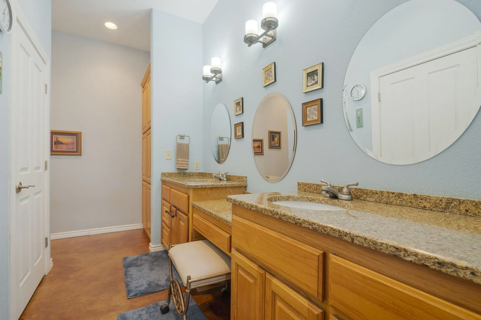 Bathroom featuring two vanities, recessed lighting, and concrete flooring