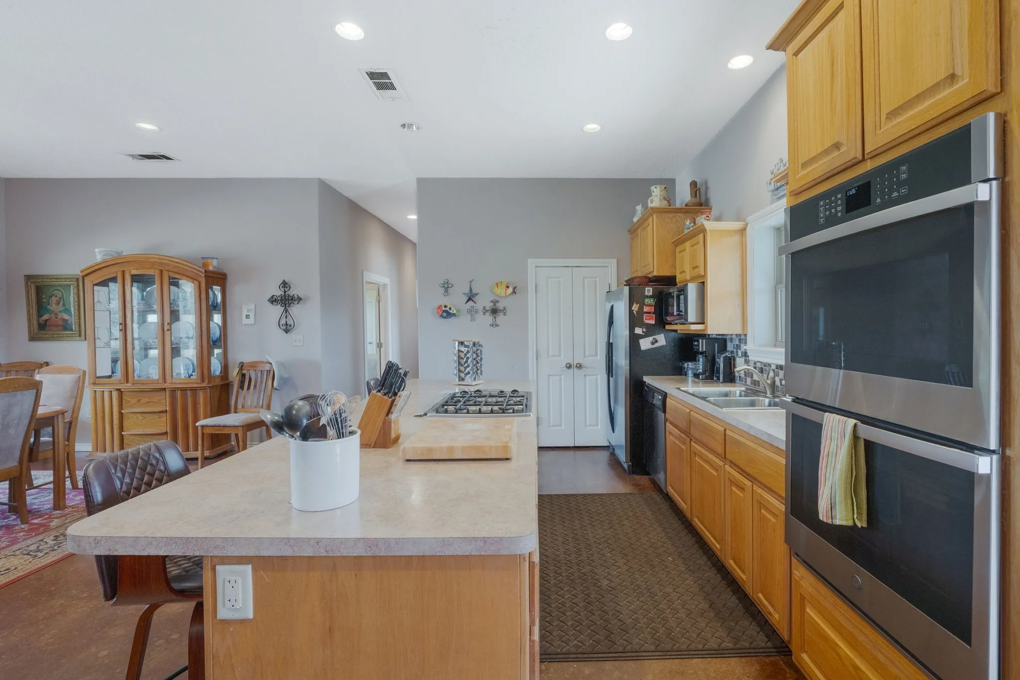 Kitchen featuring stainless steel appliances, a breakfast bar, light countertops, a center island, and recessed lighting
