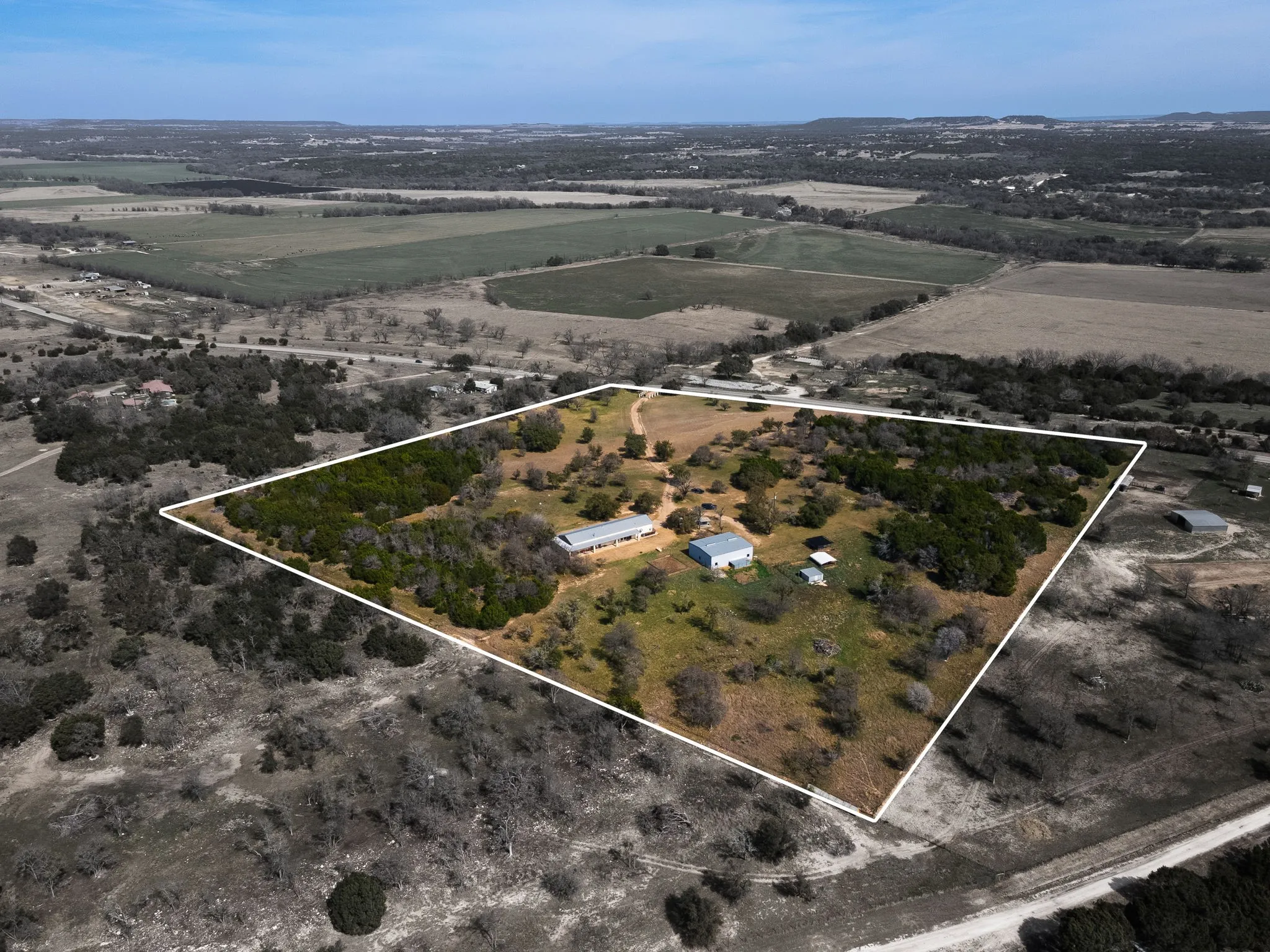 Aerial view of sparsely populated area with property parcel outlined