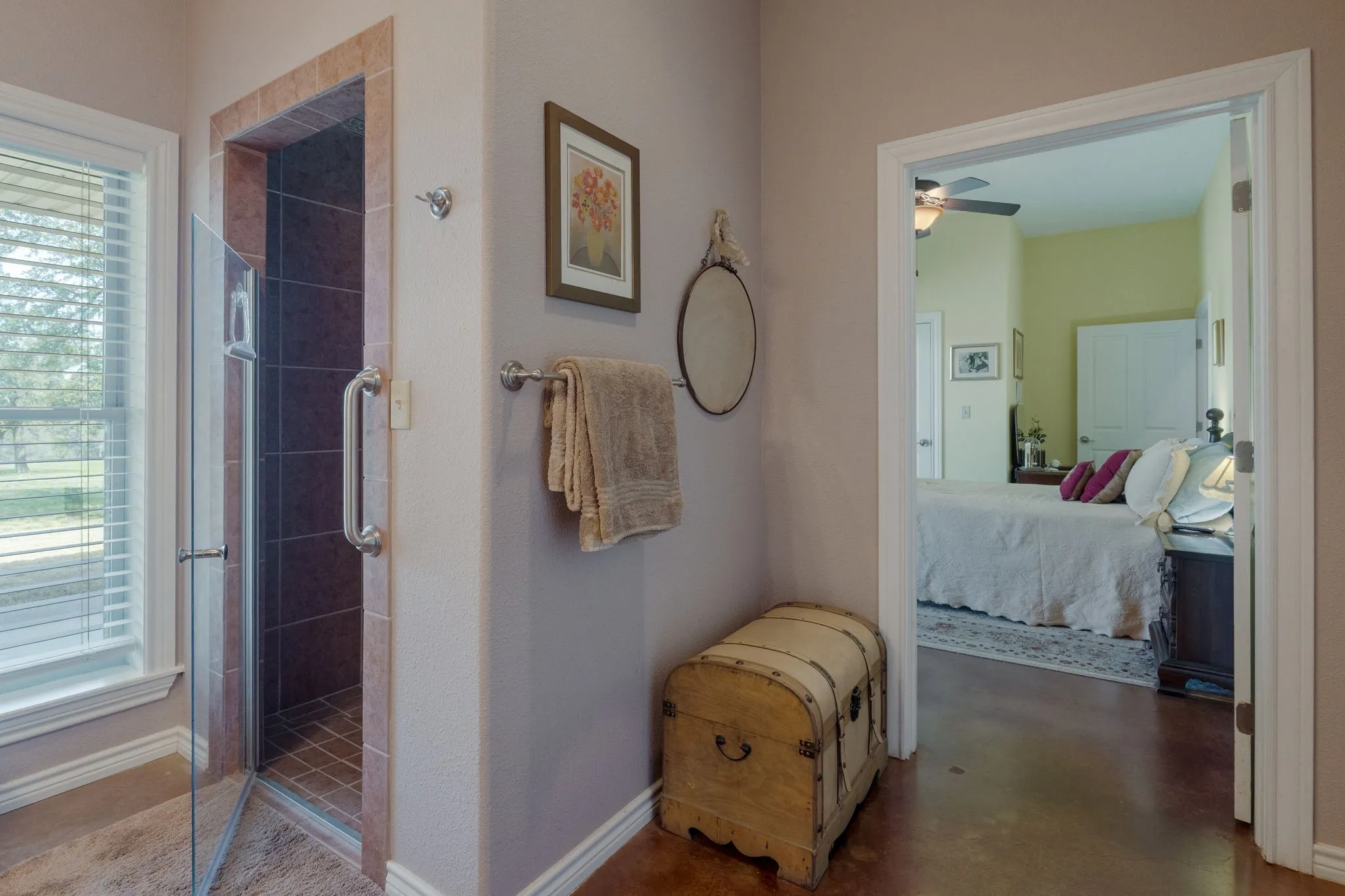 Bathroom featuring connected bathroom, a shower stall, a ceiling fan, and finished concrete floors