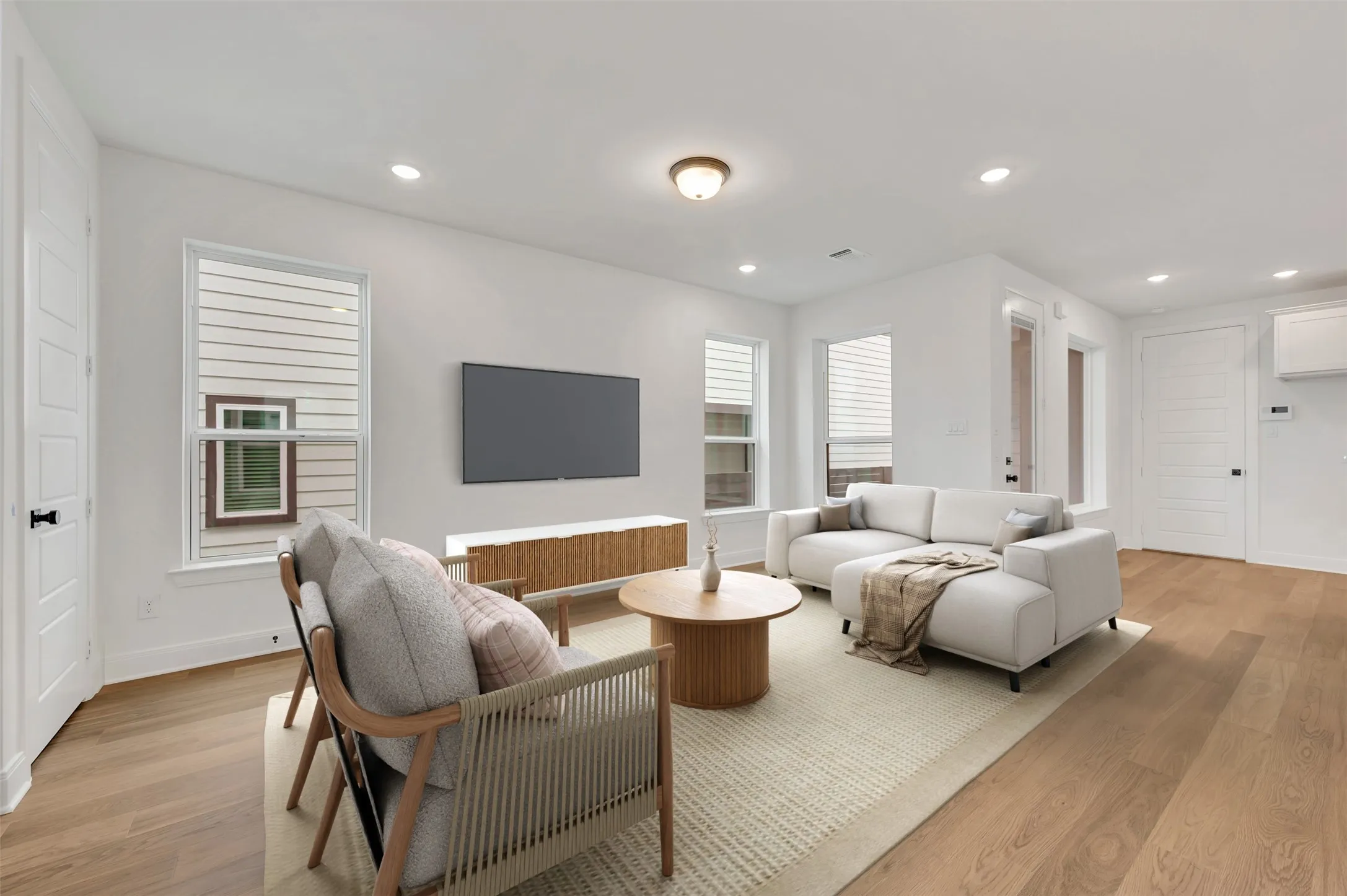 Open-concept living space featuring wood-finish flooring, recessed lighting, and white trim throughout