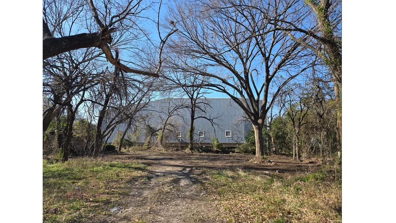 Mature trees with a winding creek in a park like setting.