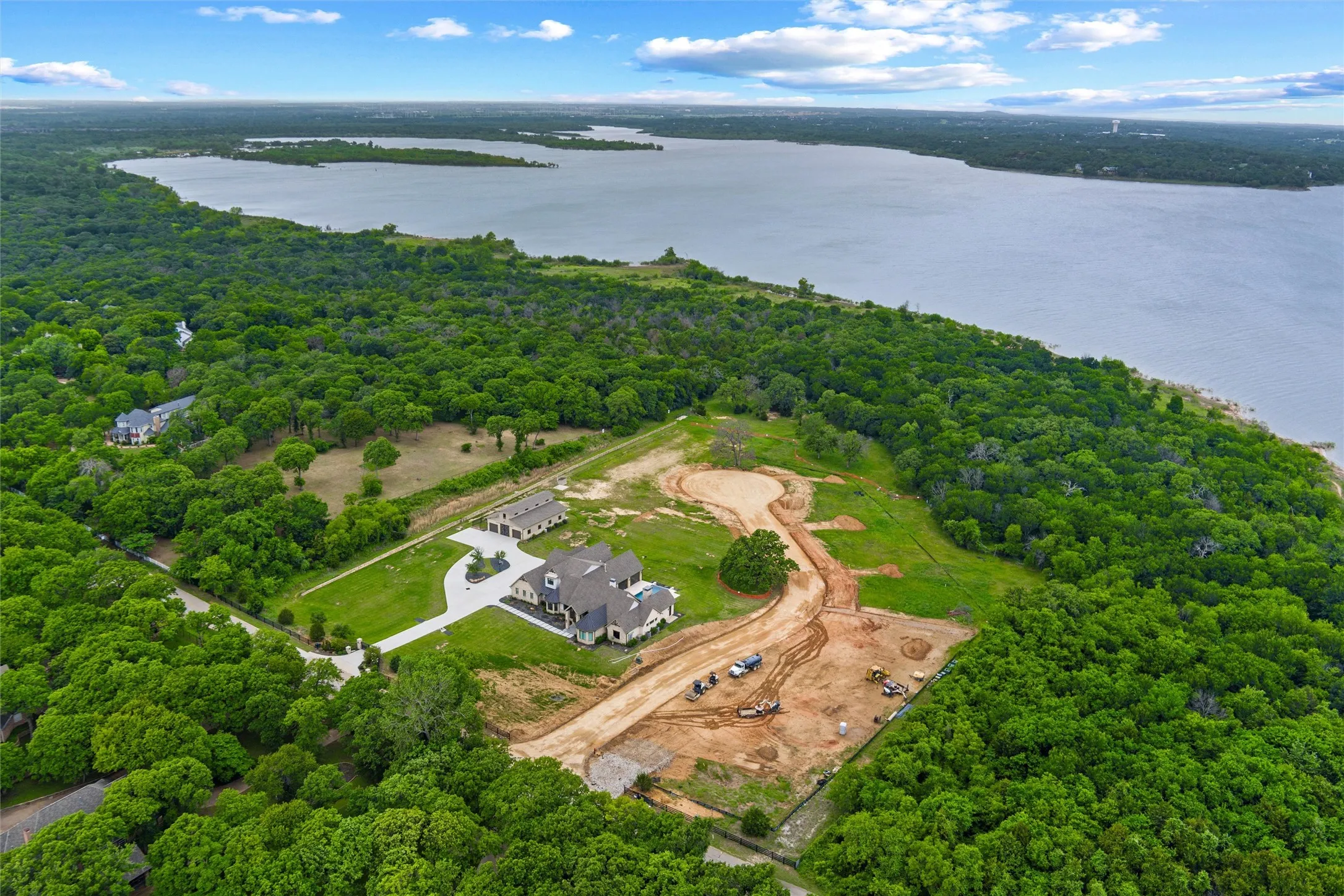 Expansive land parcel with direct lake frontage, featuring a newly constructed residence and a detached structure