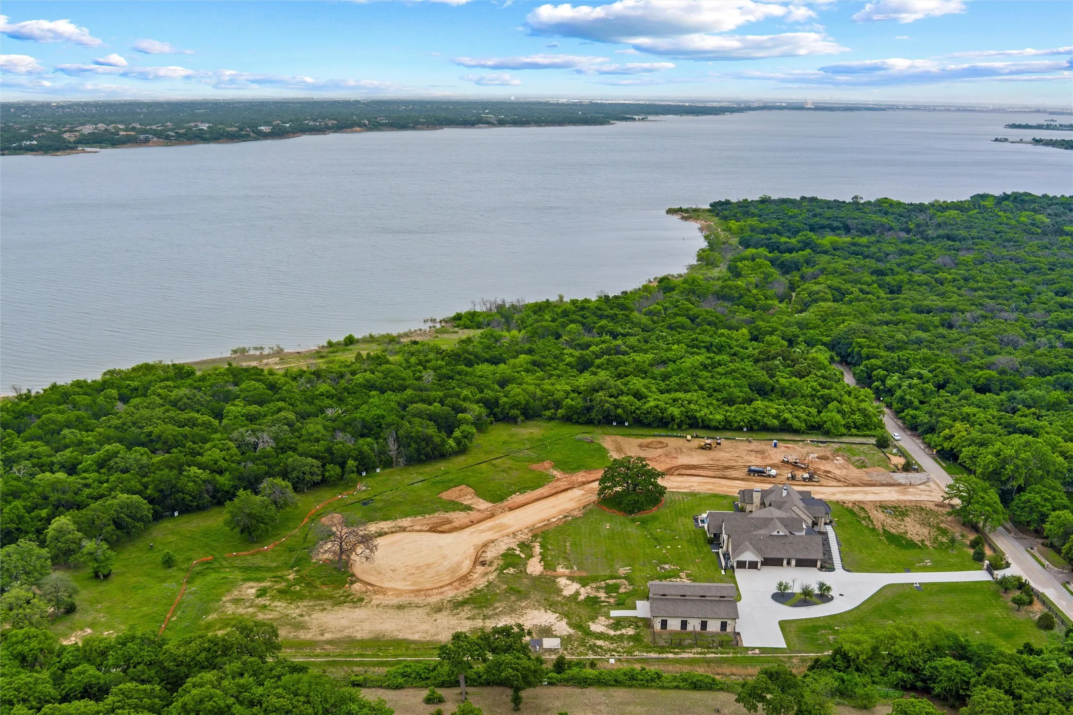 Expansive property featuring a waterfront setting, substantial wooded areas, and a paved private drive