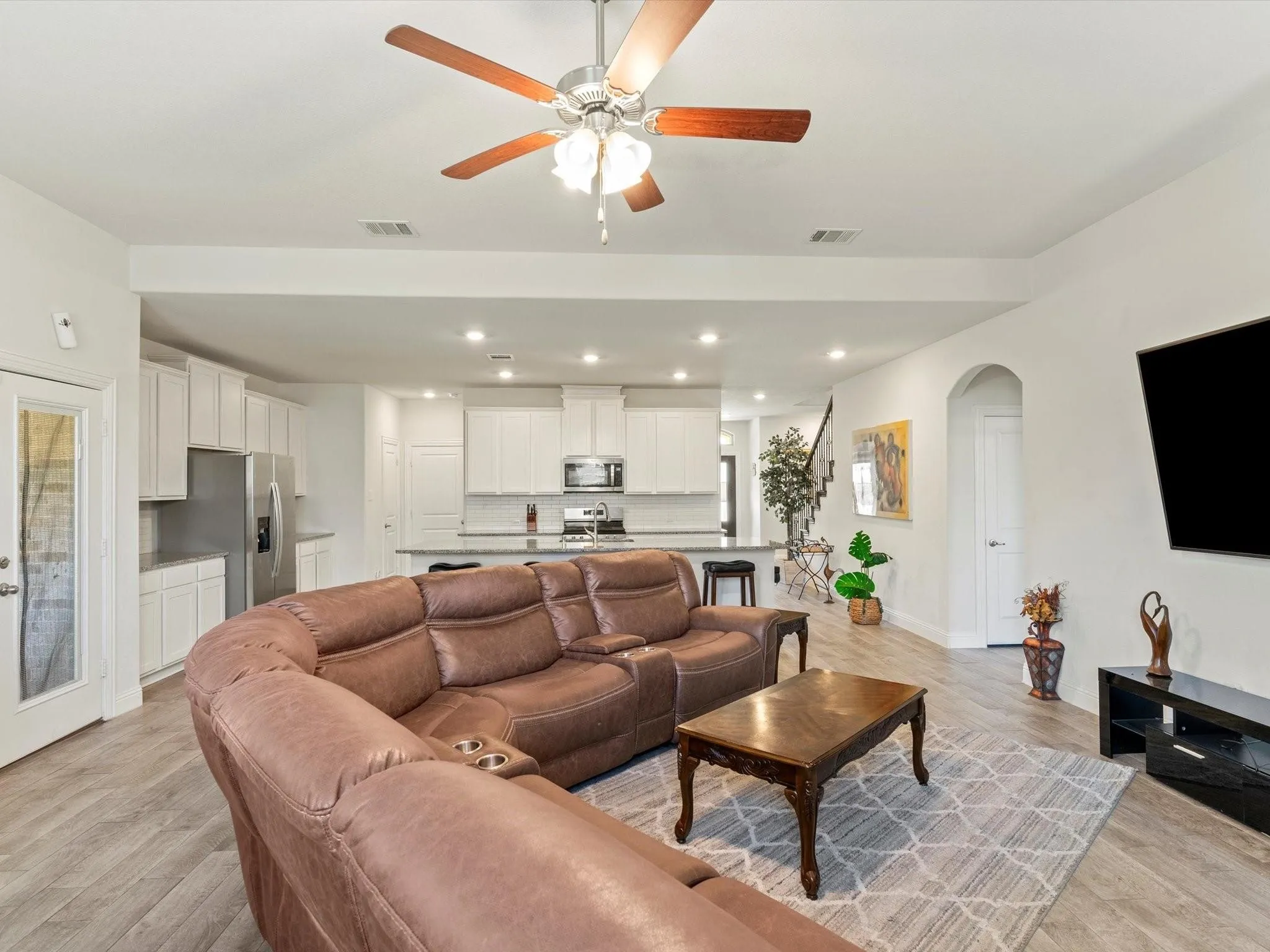 Open-concept living space featuring wood-finish flooring, recessed lighting, and a ceiling fan