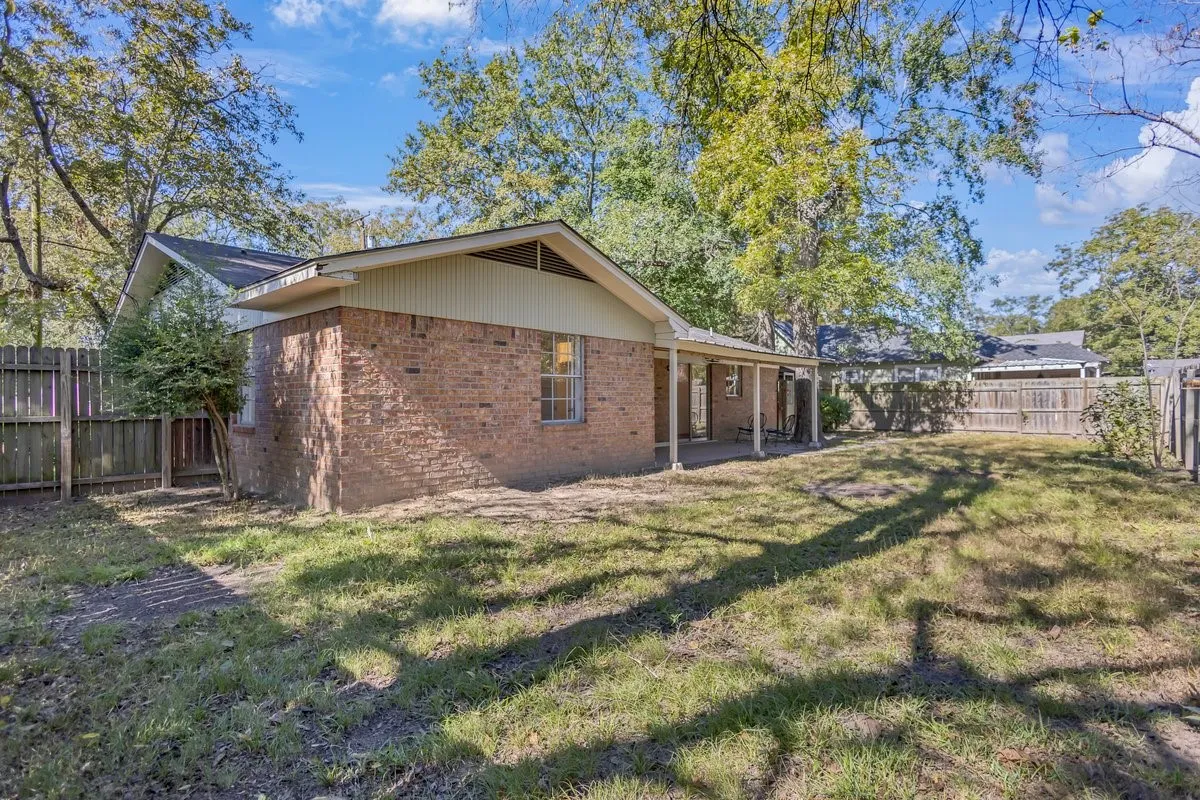 Rear view of house featuring a fenced backyard, a patio area.