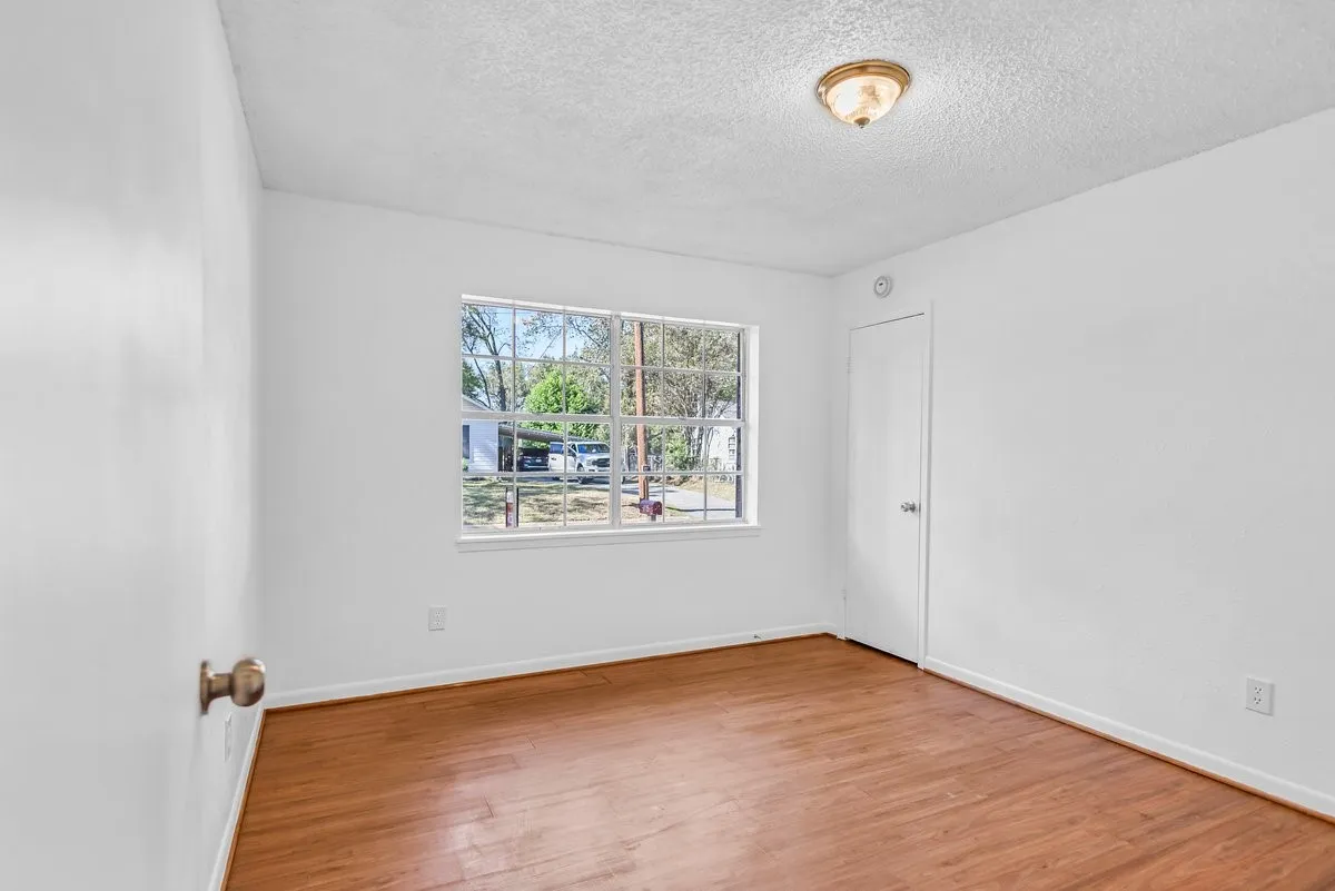 Unfurnished room with wood finished floors and a textured ceiling