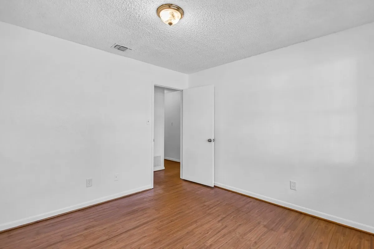 Unfurnished room with wood finished floors, and freshly painted.