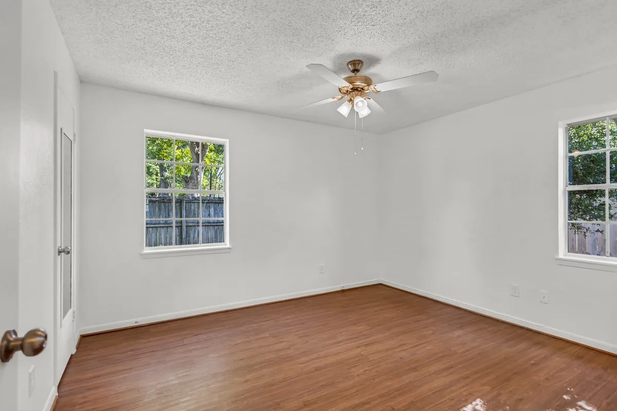  bedroom featuring dark wood-type flooring, a ceiling fan, and a textured ceiling