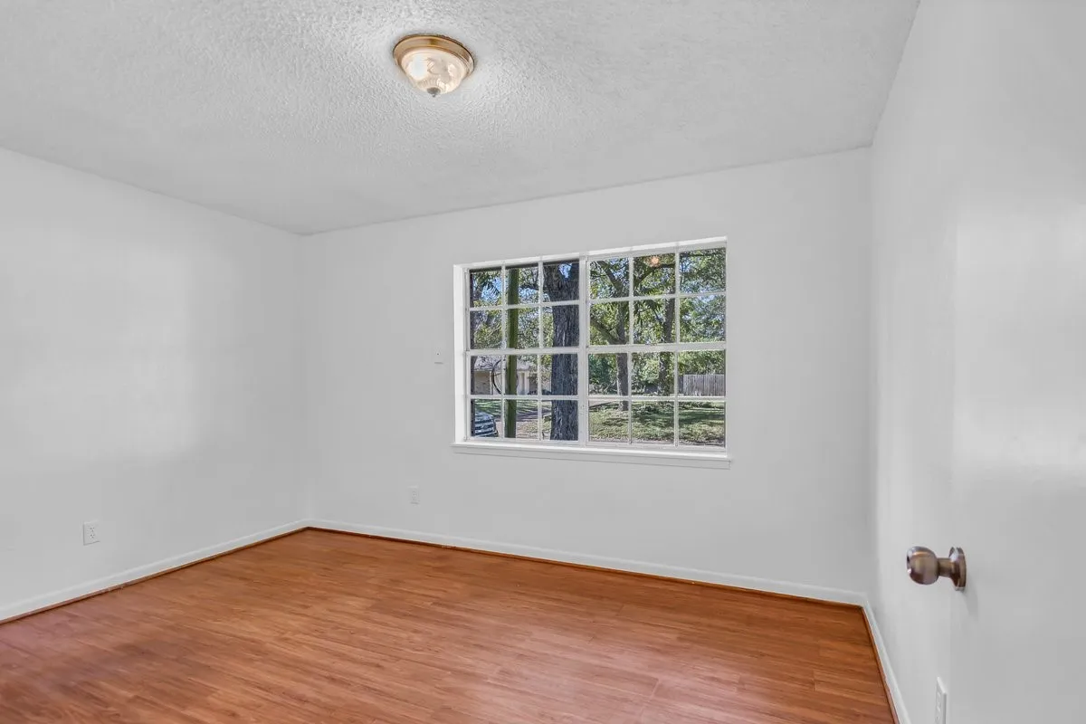Unfurnished room featuring wood finished floors and a textured ceiling