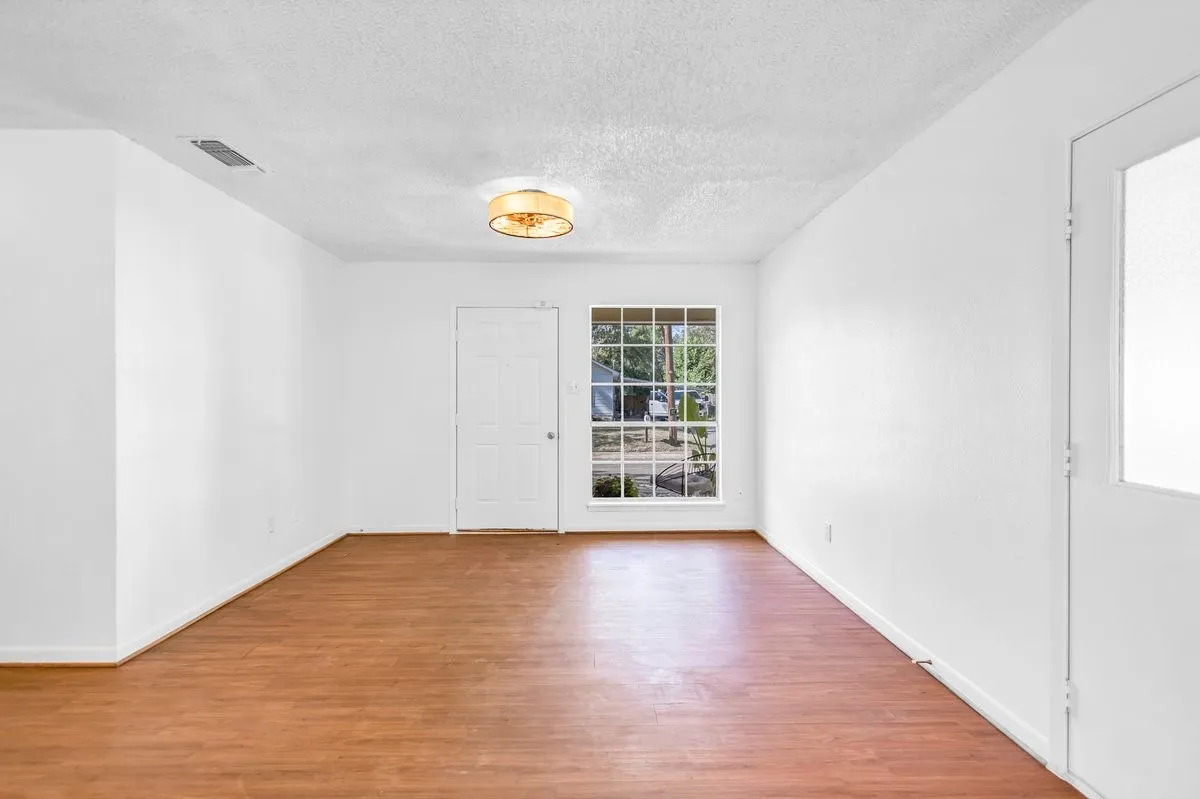 Empty room featuring light wood-style floors and a textured ceiling