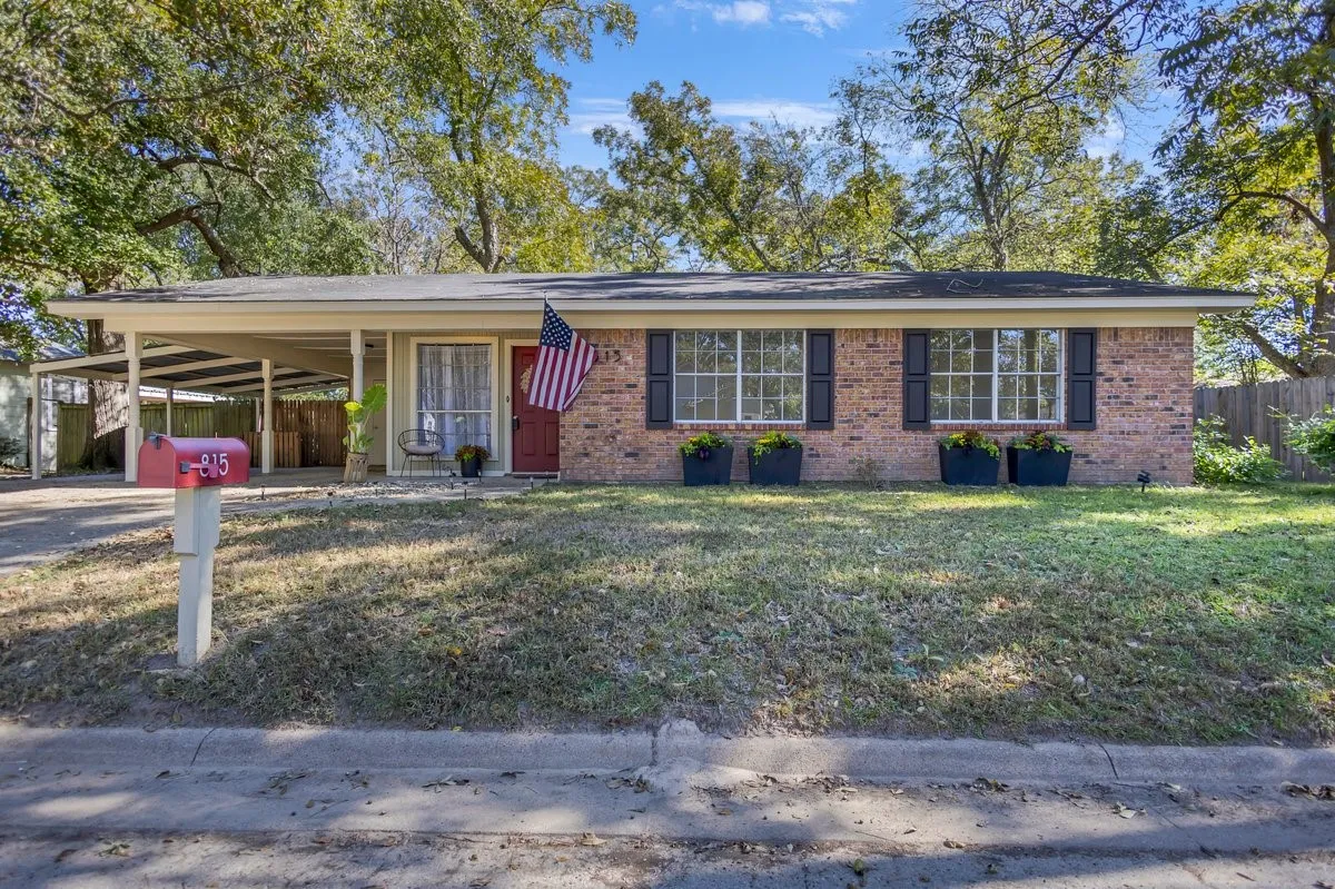 Single story home featuring covered porch, an attached carport, brick siding, and driveway