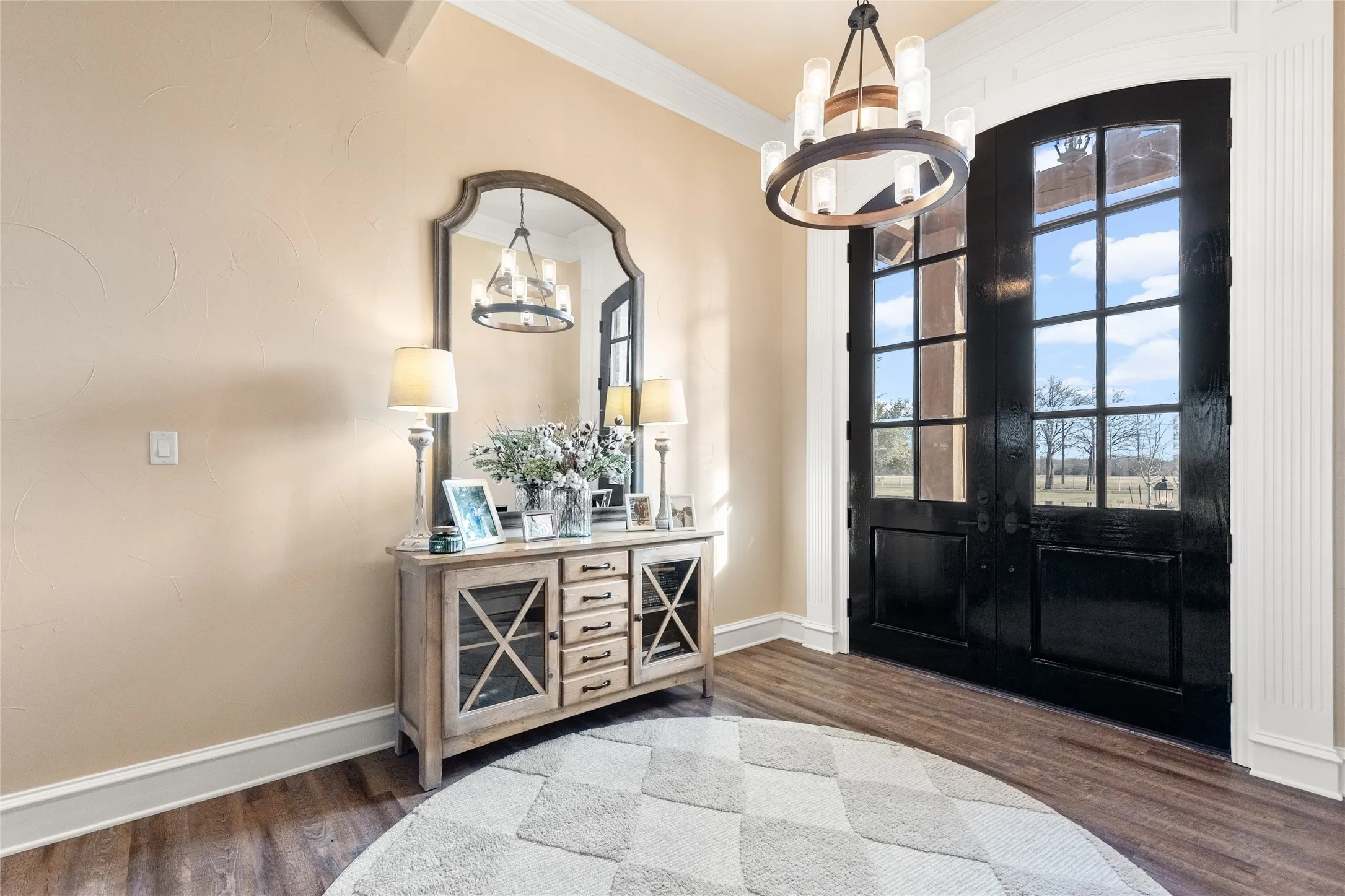 Foyer featuring a chandelier, dark wood finished floors, and crown molding