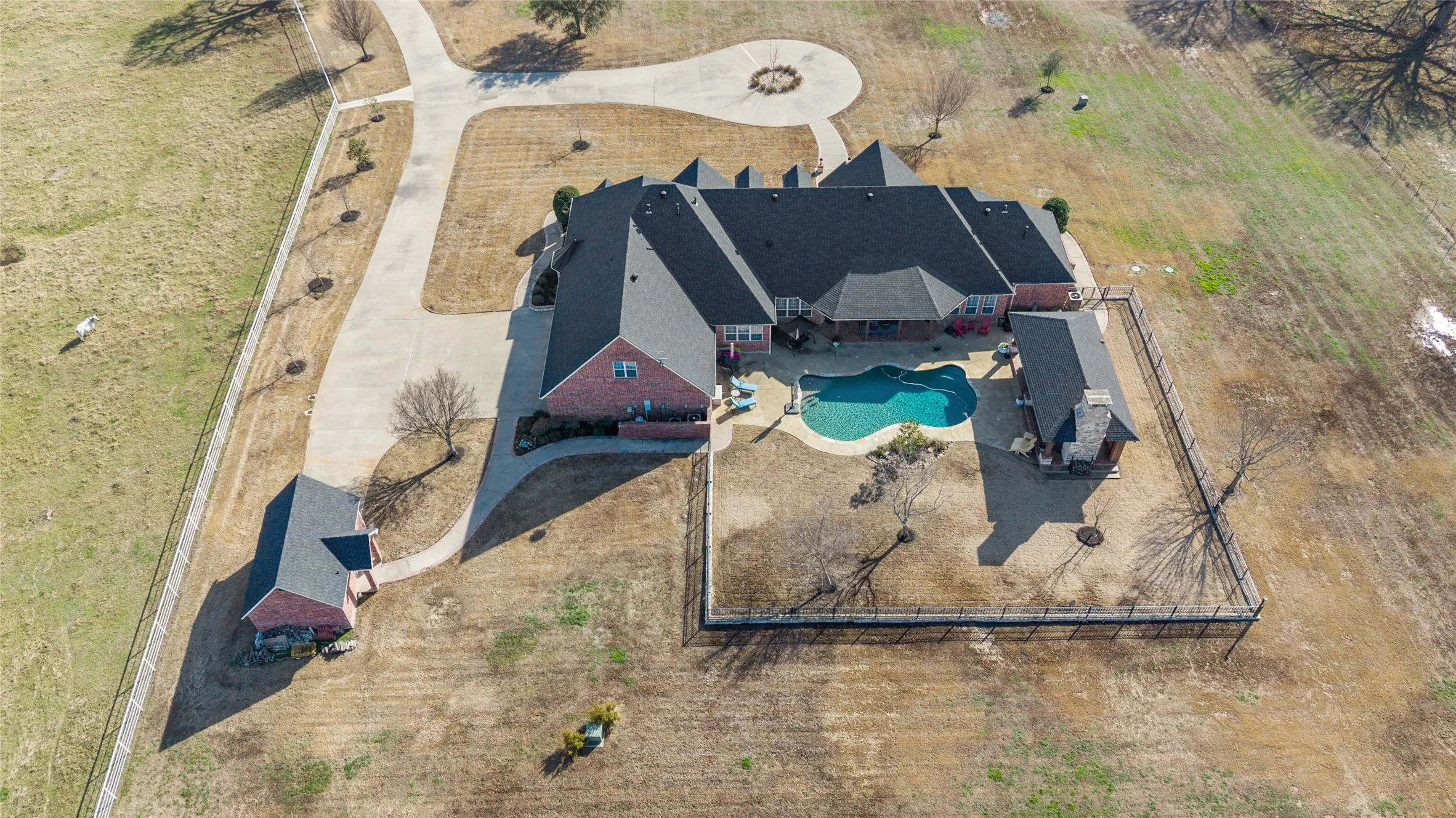 Aerial view of property and surrounding area featuring a pool area
