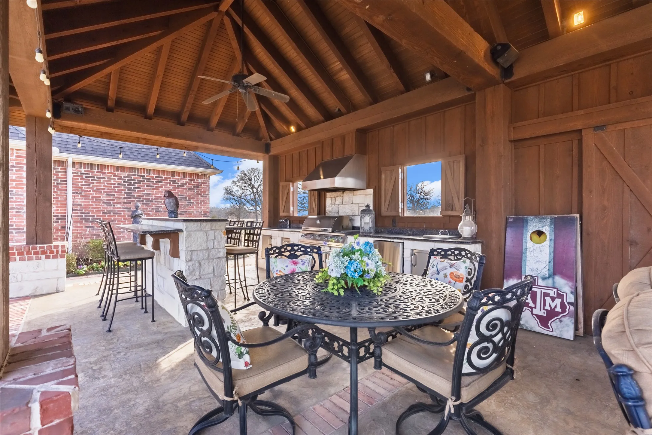 View of patio featuring a ceiling fan, an outdoor kitchen, and an outdoor bar and dining area