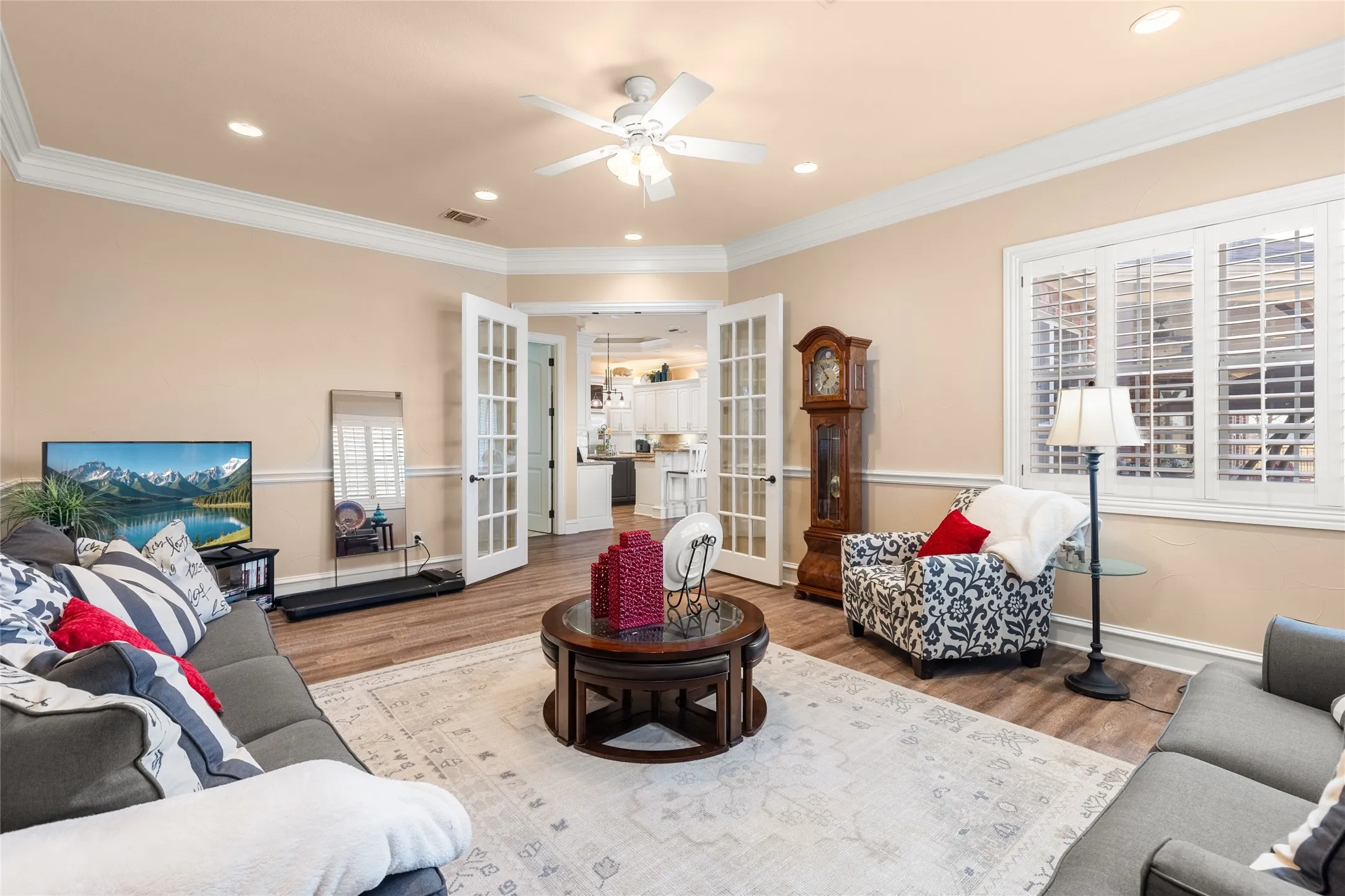 Living area with french doors, wood finished floors, crown molding, ceiling fan, and recessed lighting