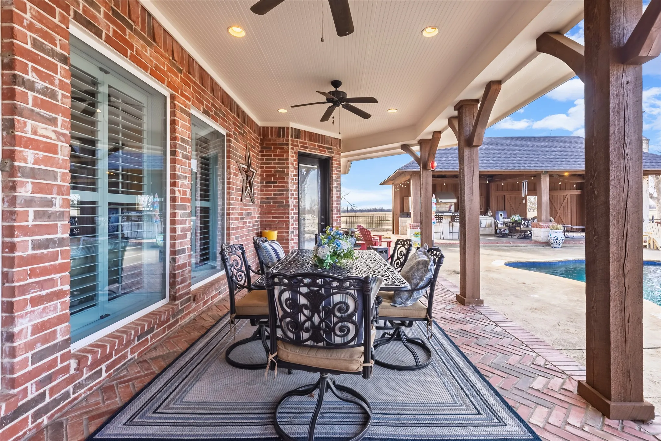 View of patio with outdoor dining space, an outdoor pool, and ceiling fan