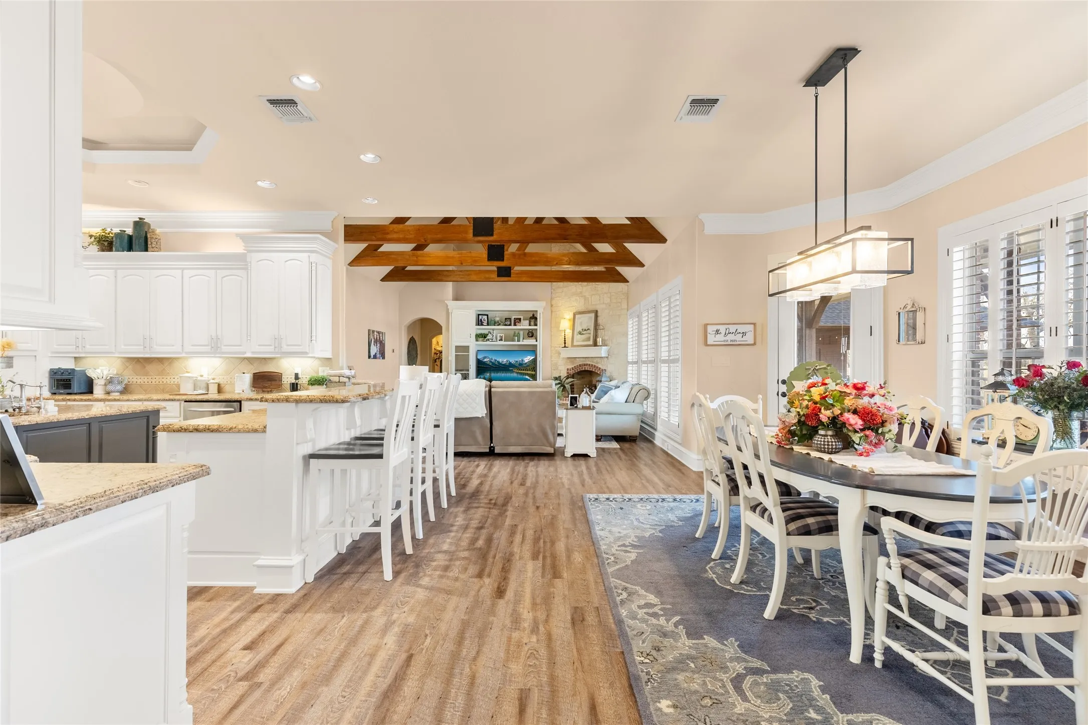 Dining room featuring crown molding, recessed lighting, light wood finished floors, beamed ceiling, and arched walkways