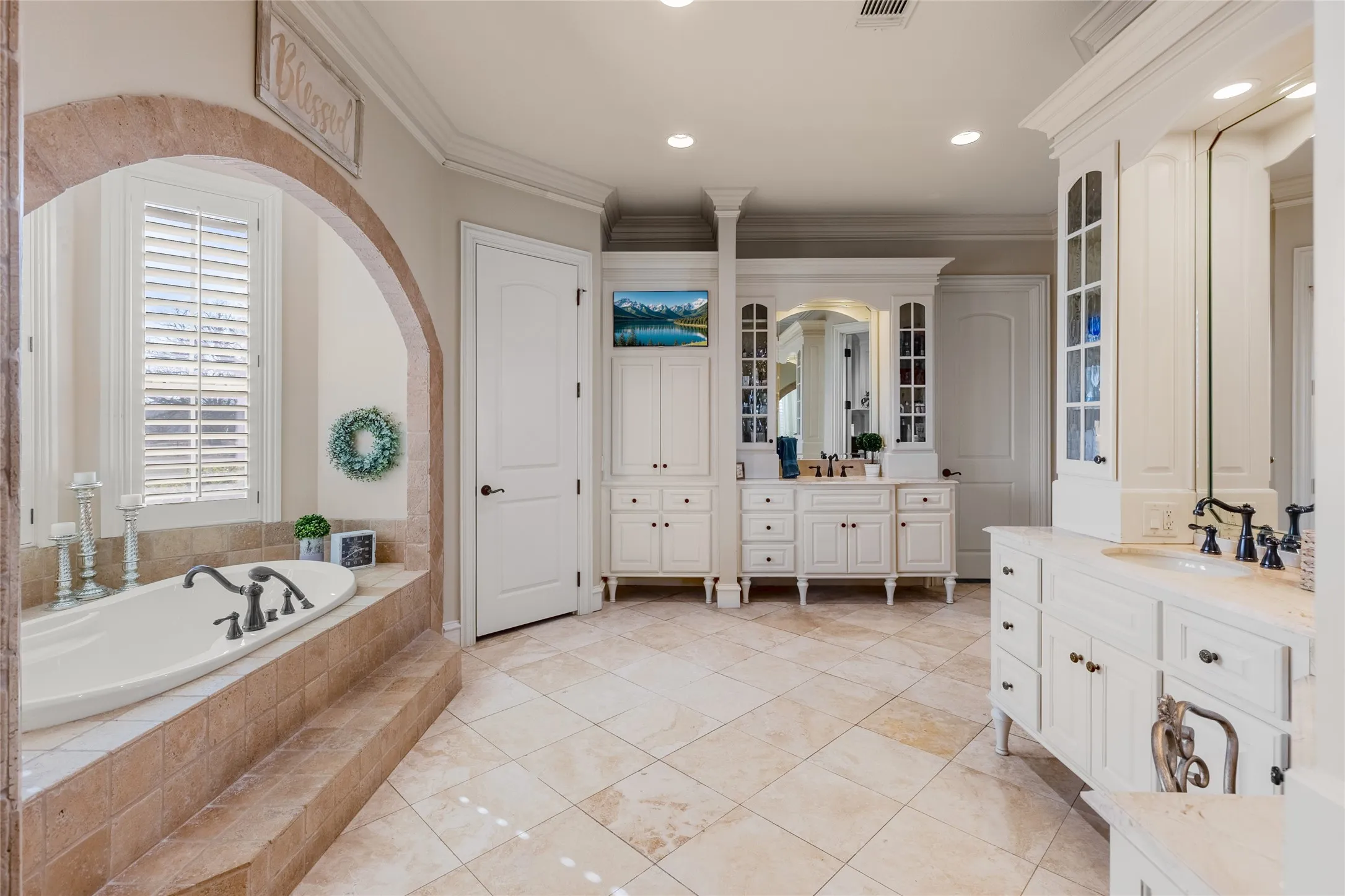 Bathroom with two vanities, crown molding, recessed lighting, a bath, and light tile patterned floors