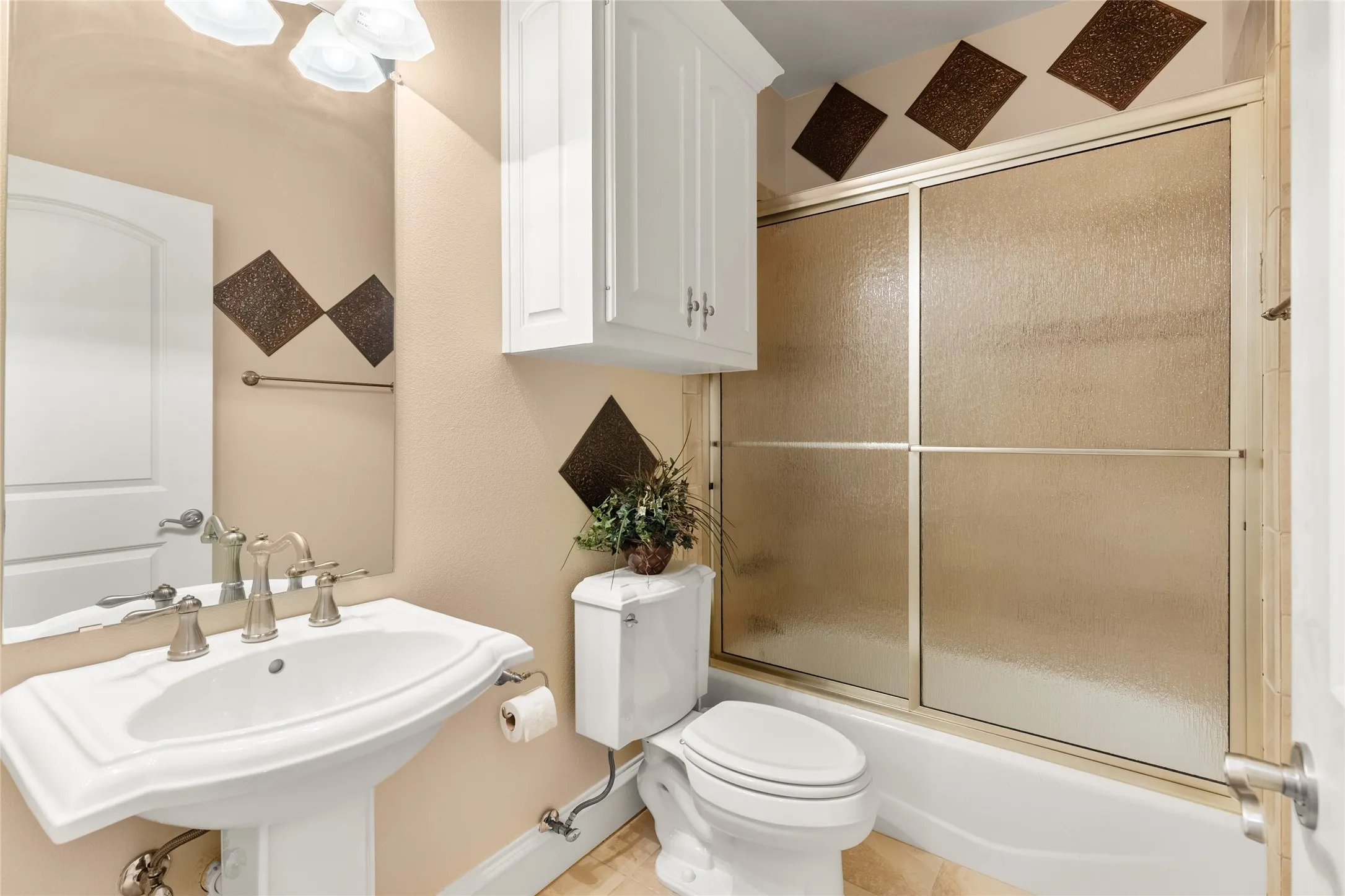 Full bathroom with combined bath / shower with glass door, tile patterned floors, and a chandelier