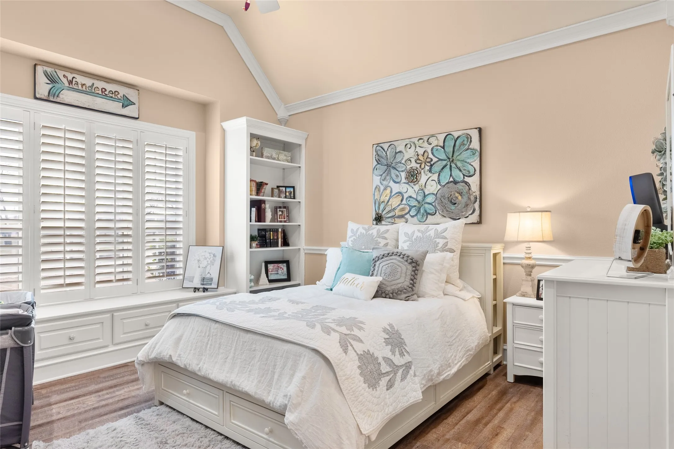 Bedroom featuring crown molding, wood finished floors, vaulted ceiling, and a ceiling fan