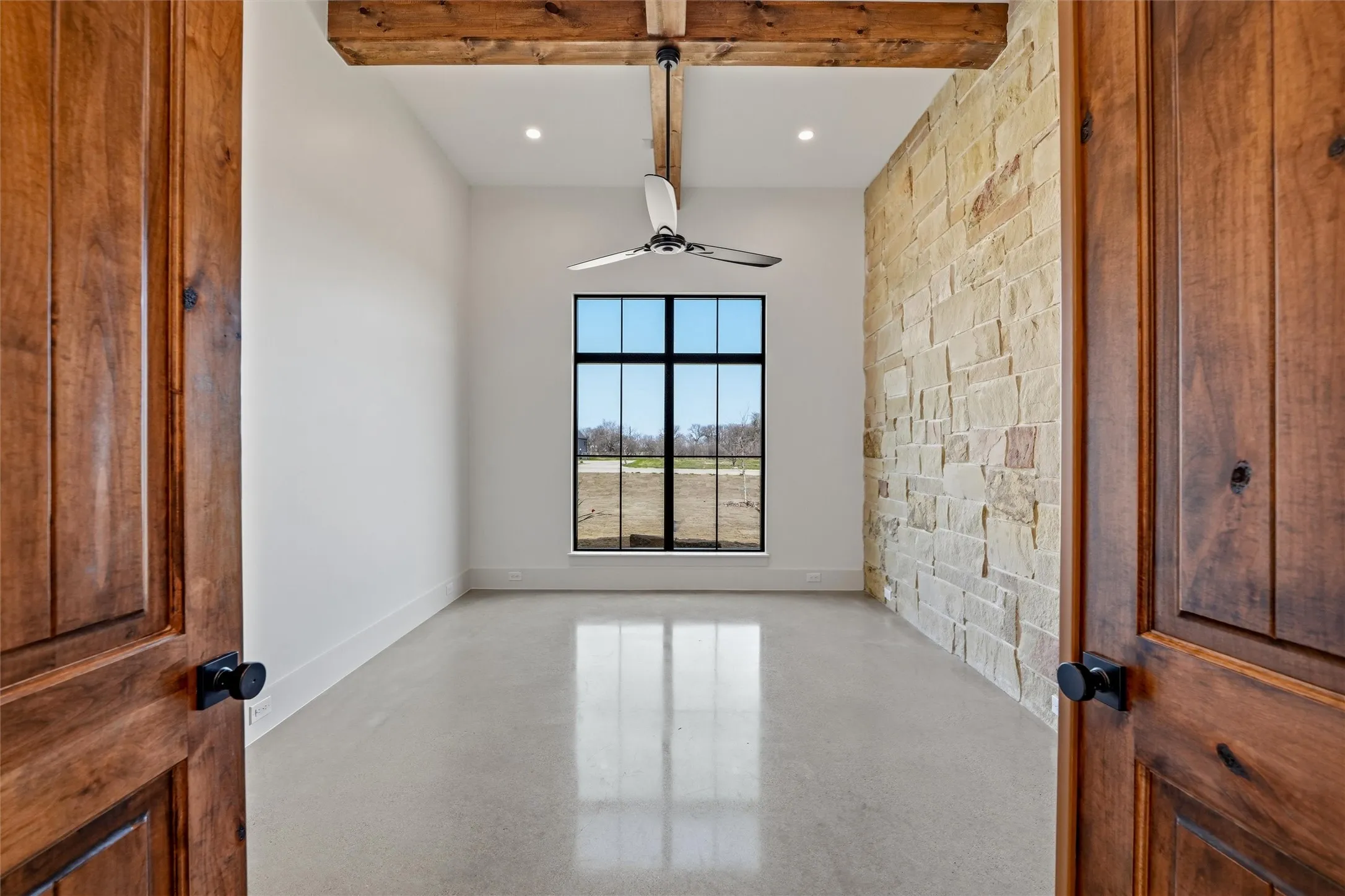 Office featuring beamed ceiling and stone accent wall